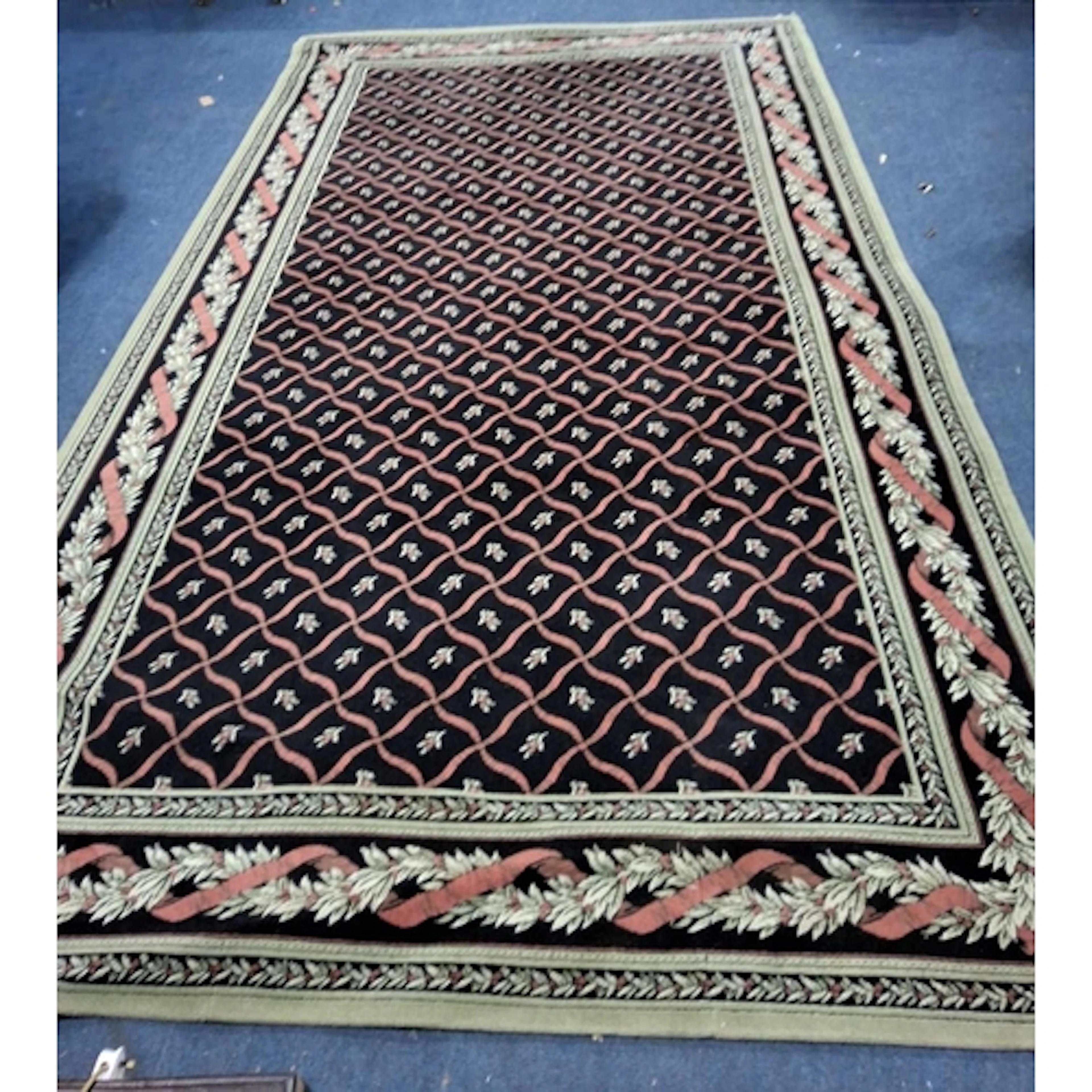 A LARGE BLACK GROUND RECTANGULAR WOOLEN RUG, with repeating ...
