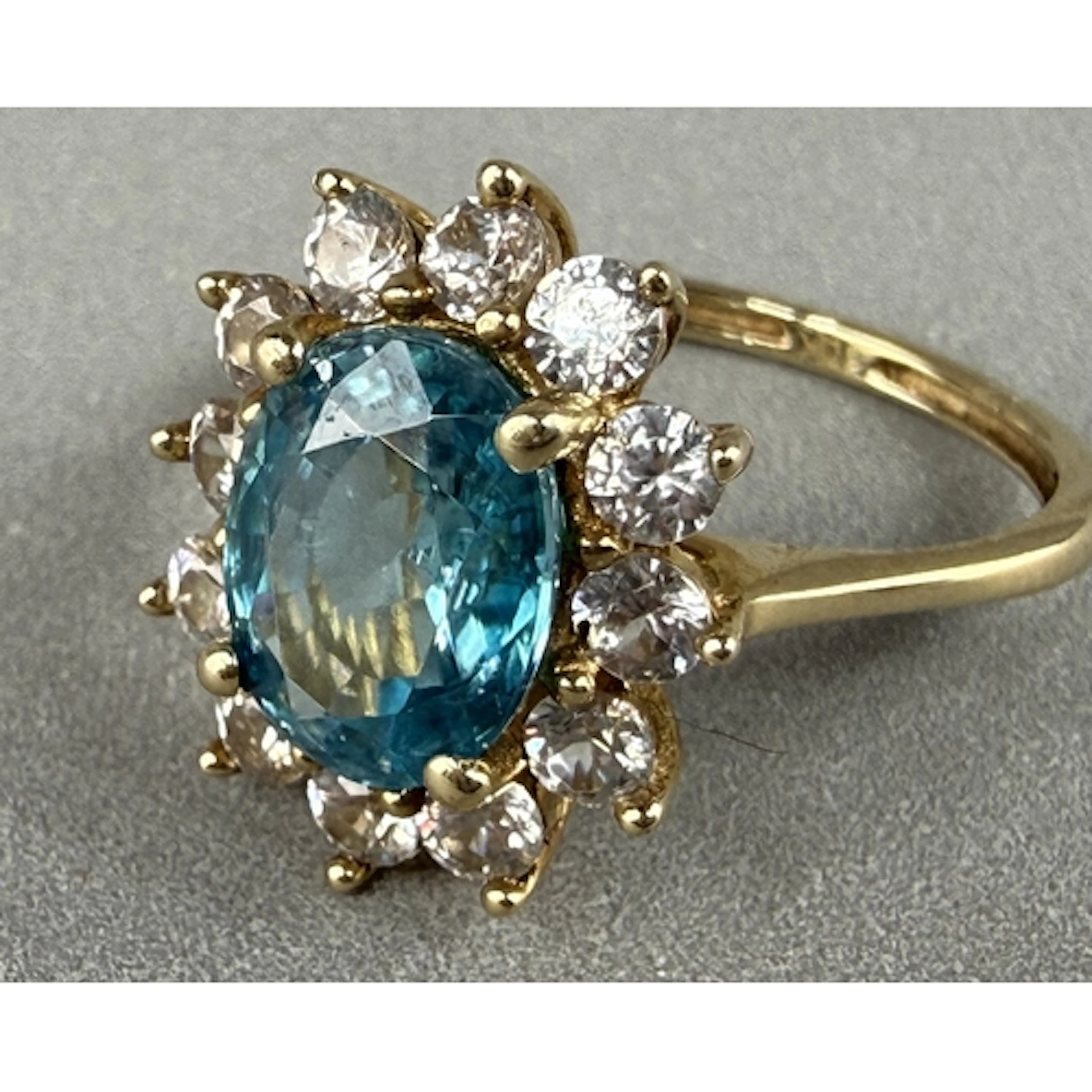 Jewellery: a yellow metal cluster ring, a central topaz with...