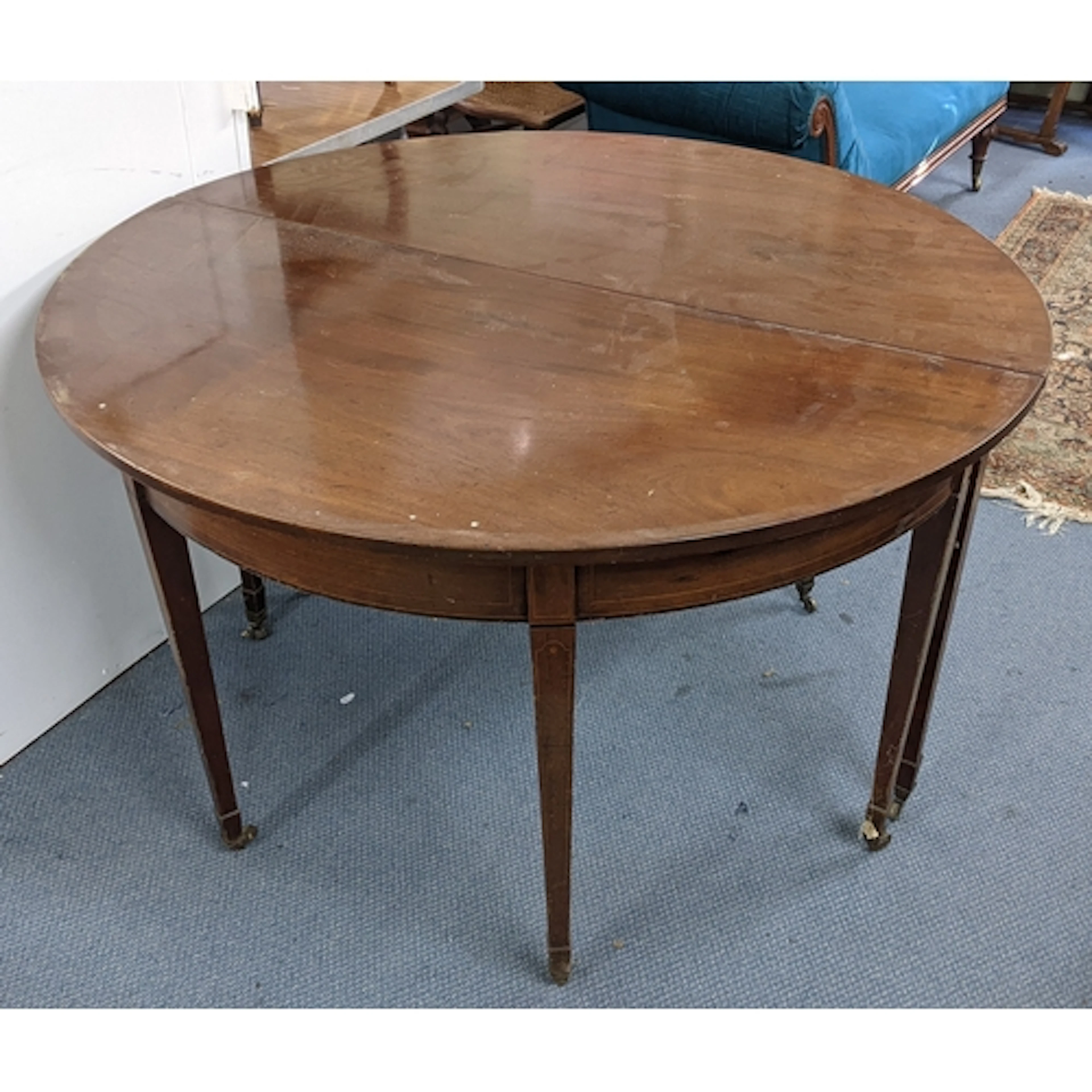A George III mahogany dining table having string inlaid and ...
