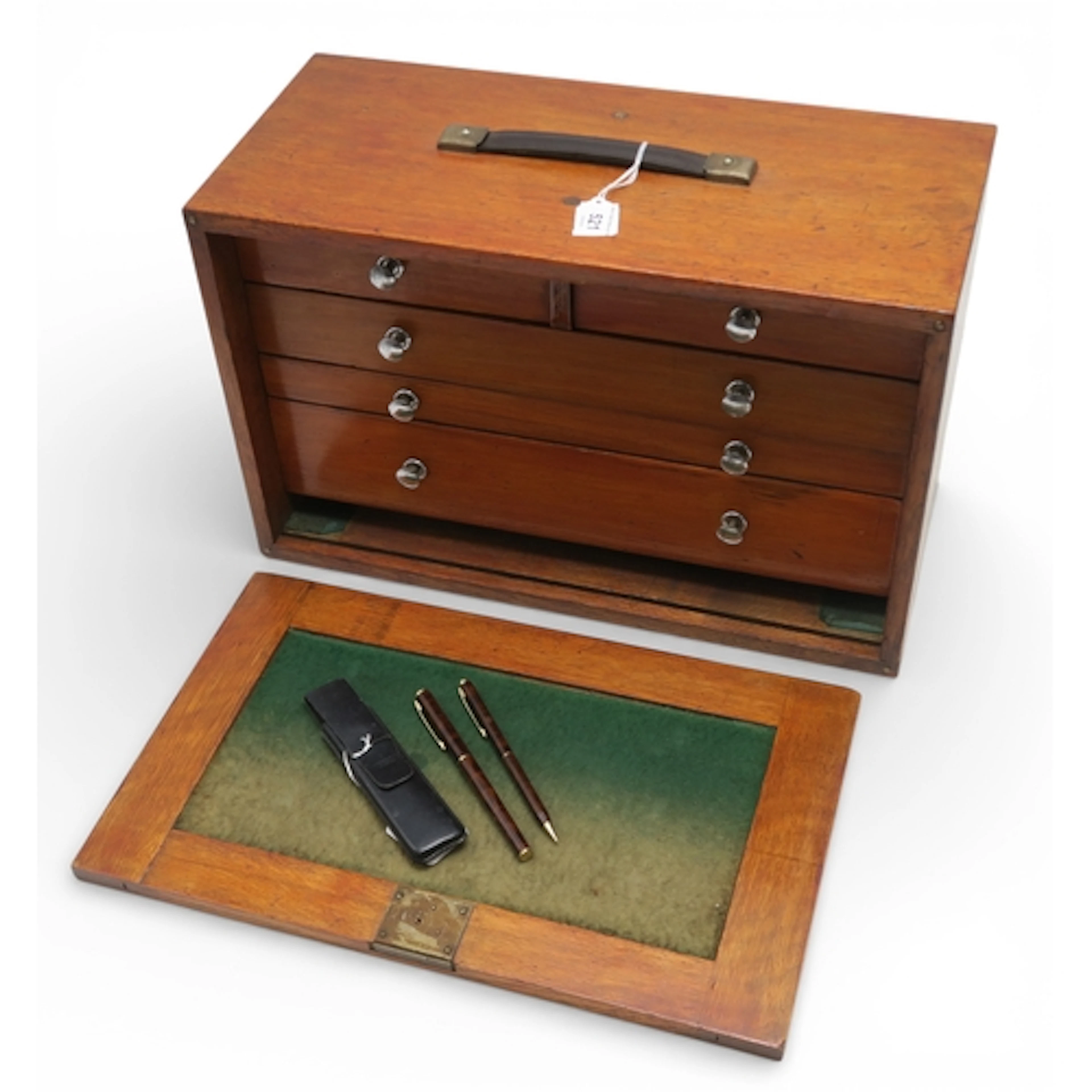 A stained oak multi-drawer collector's chest, the drop front...