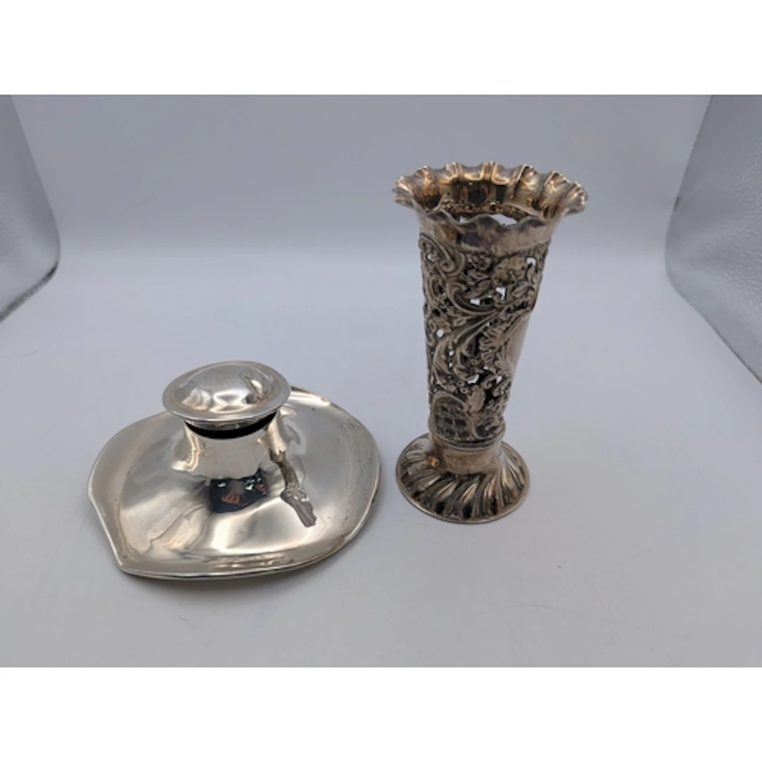 A silver vase of pierced design with a flared rim on a circu...