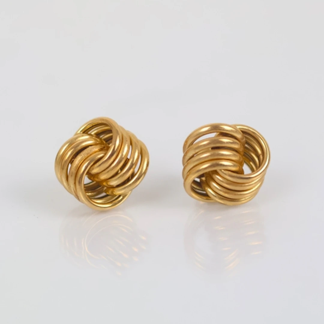A pair of 9ct gold ‘knot’ earrings, of typical form with hal...