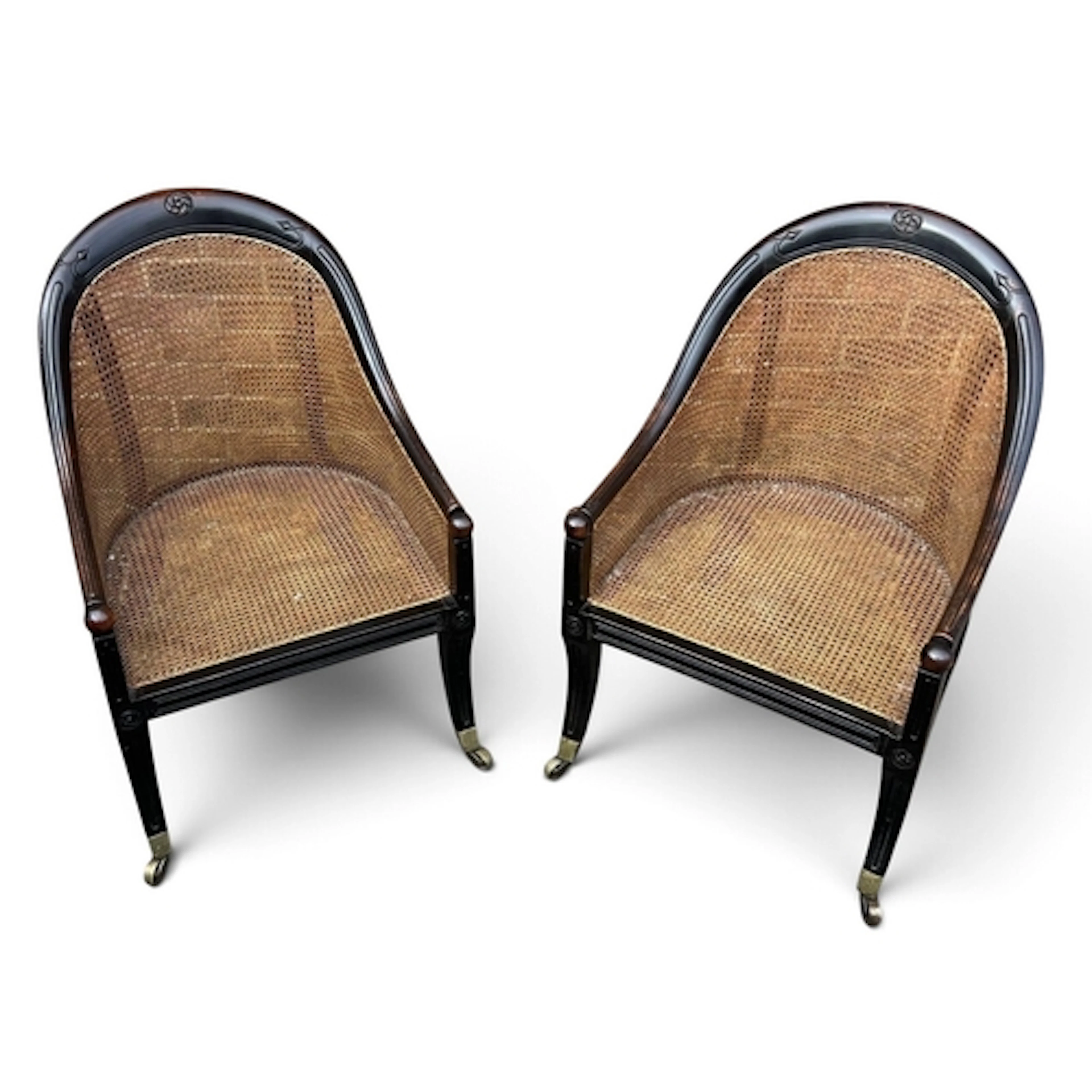 A PAIR OF CANE BACK ARMCHAIRS On brass castors. With cushion...