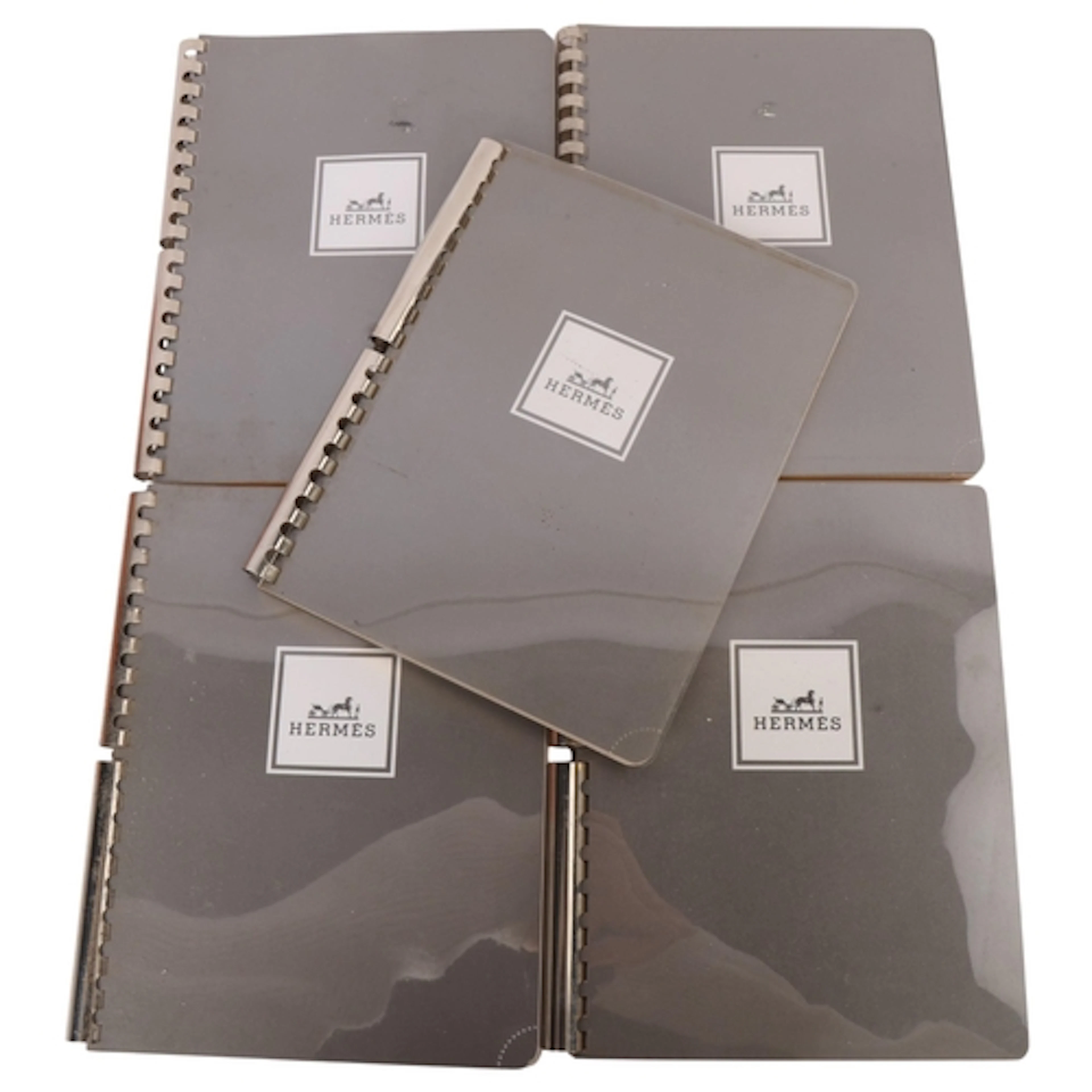 Five Hermes notebooks with steel ring bindings and gilt edge...