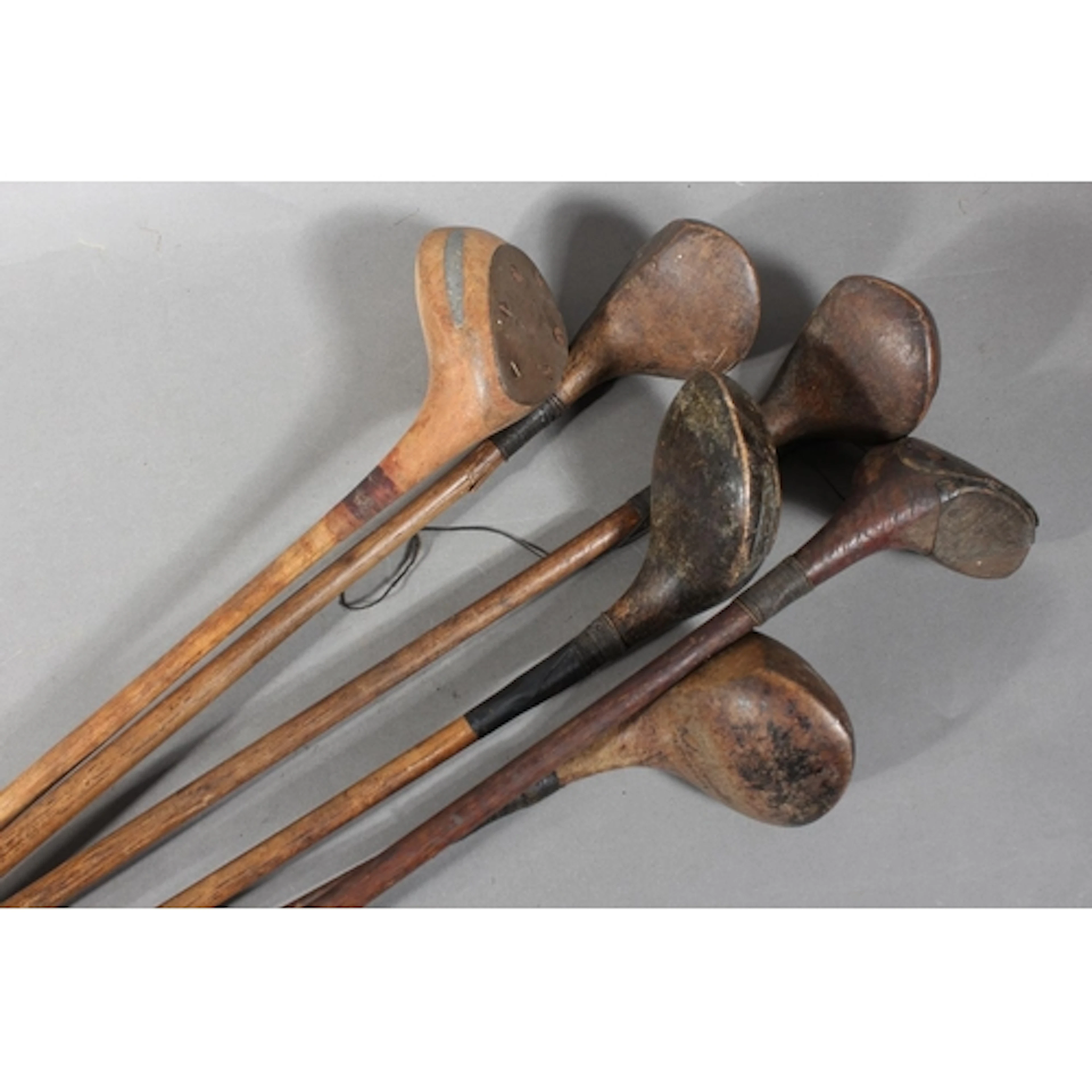 Six hickory shafted golf clubs to include Kirkcaldy Ltd wood...
