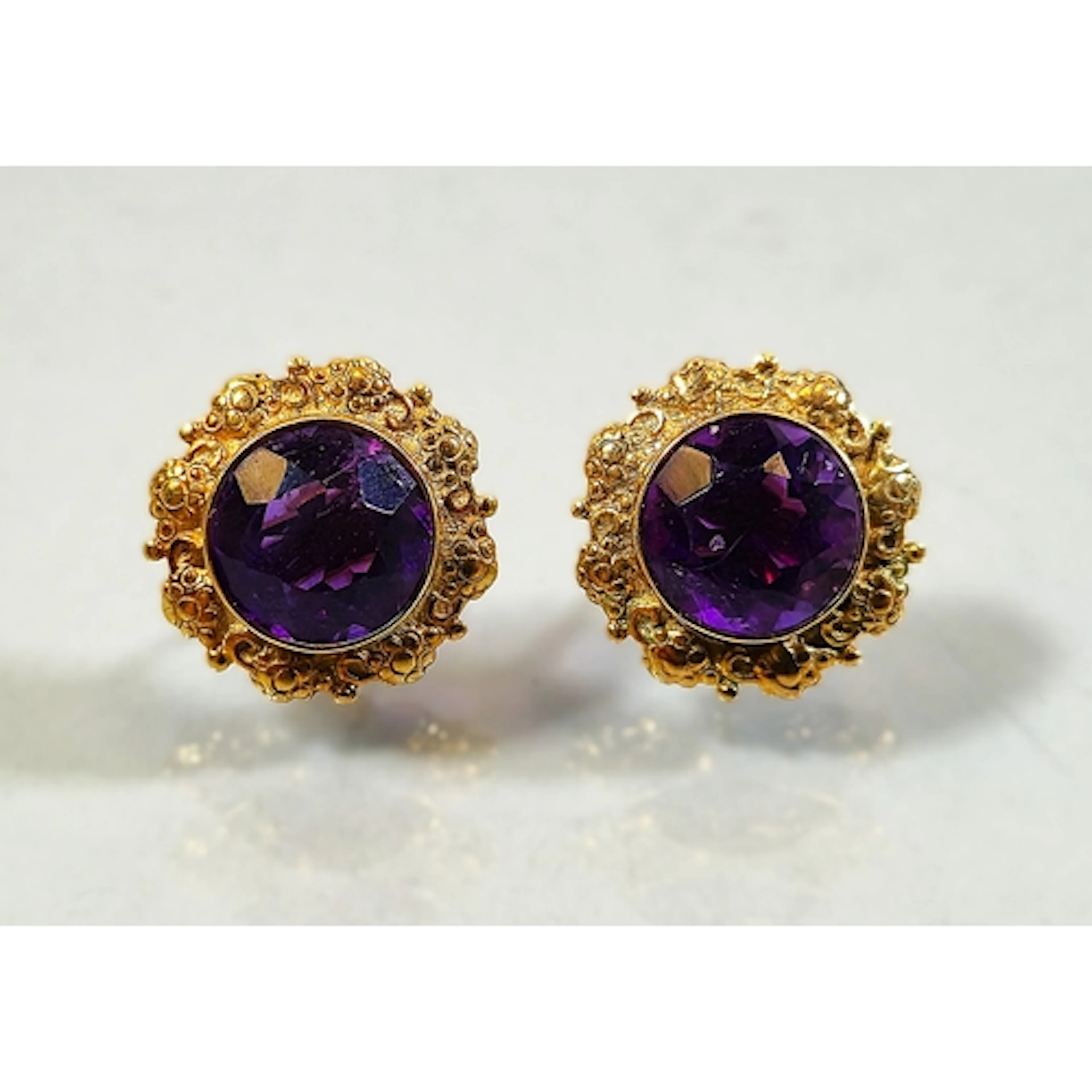Pair of yellow metal amethyst earrings, set with a faceted a...