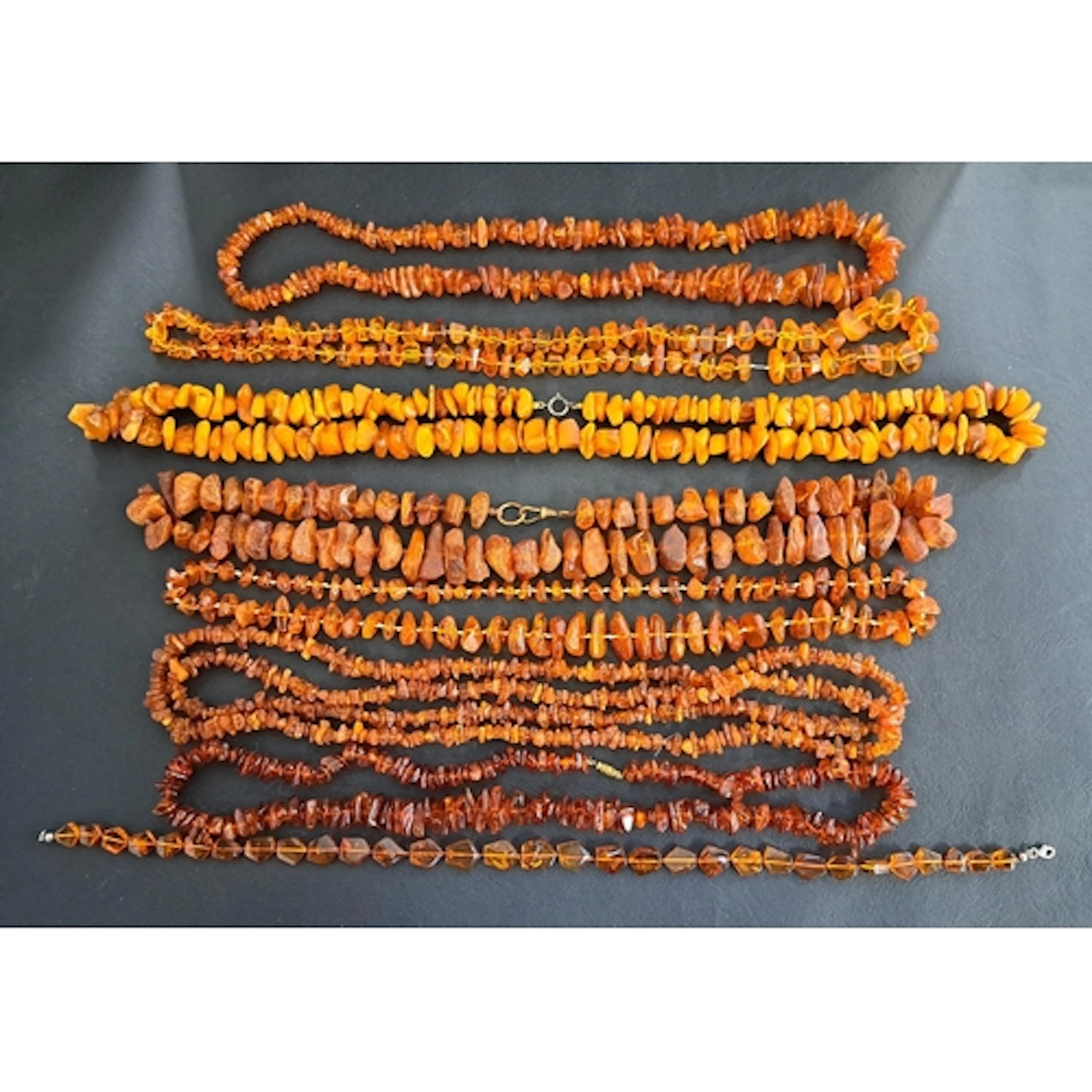 SELECTION OF AMBER AND AMBER COLOURED BEAD NECKLACES of vari...