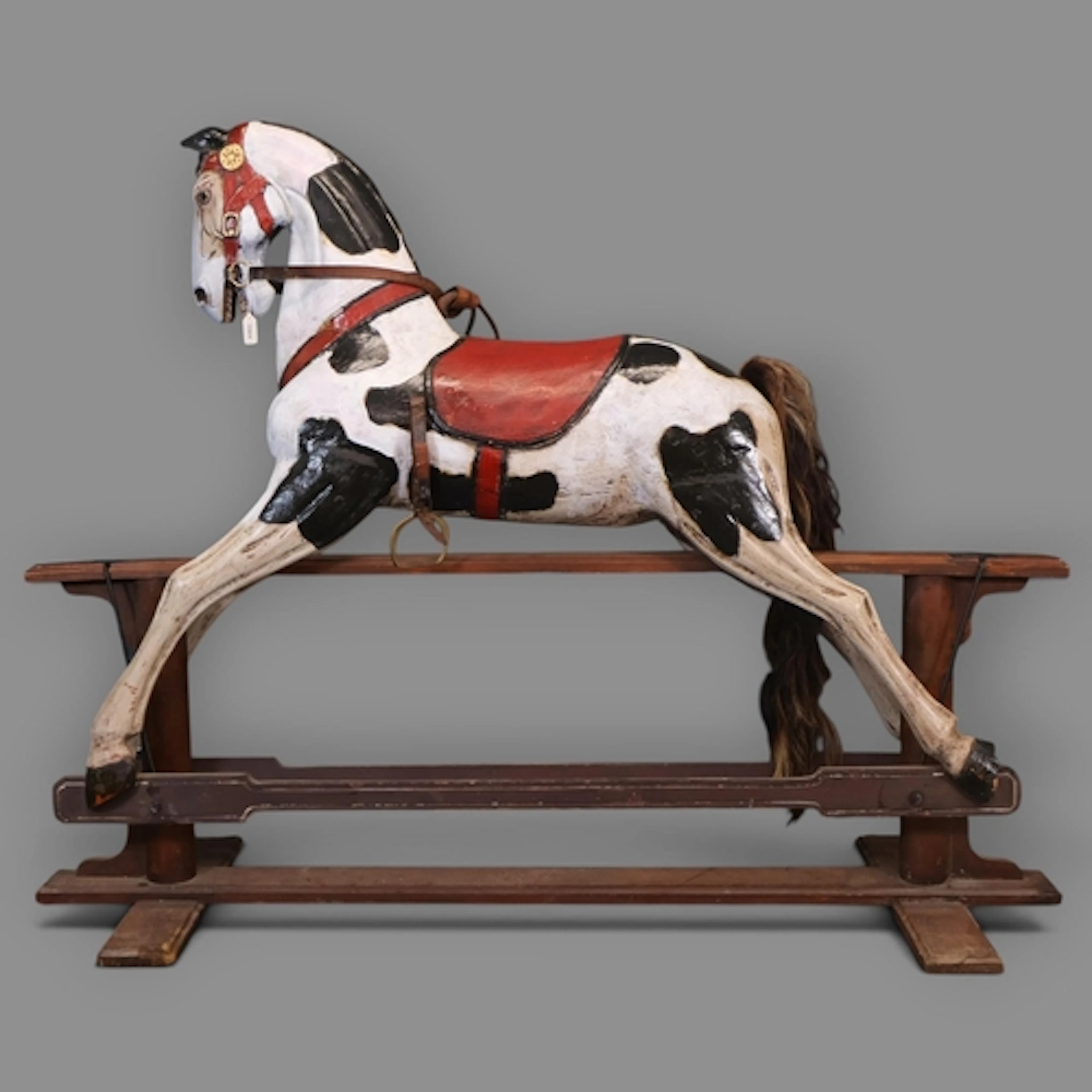 An antique hand carved and painted rocking horse on stand, ...