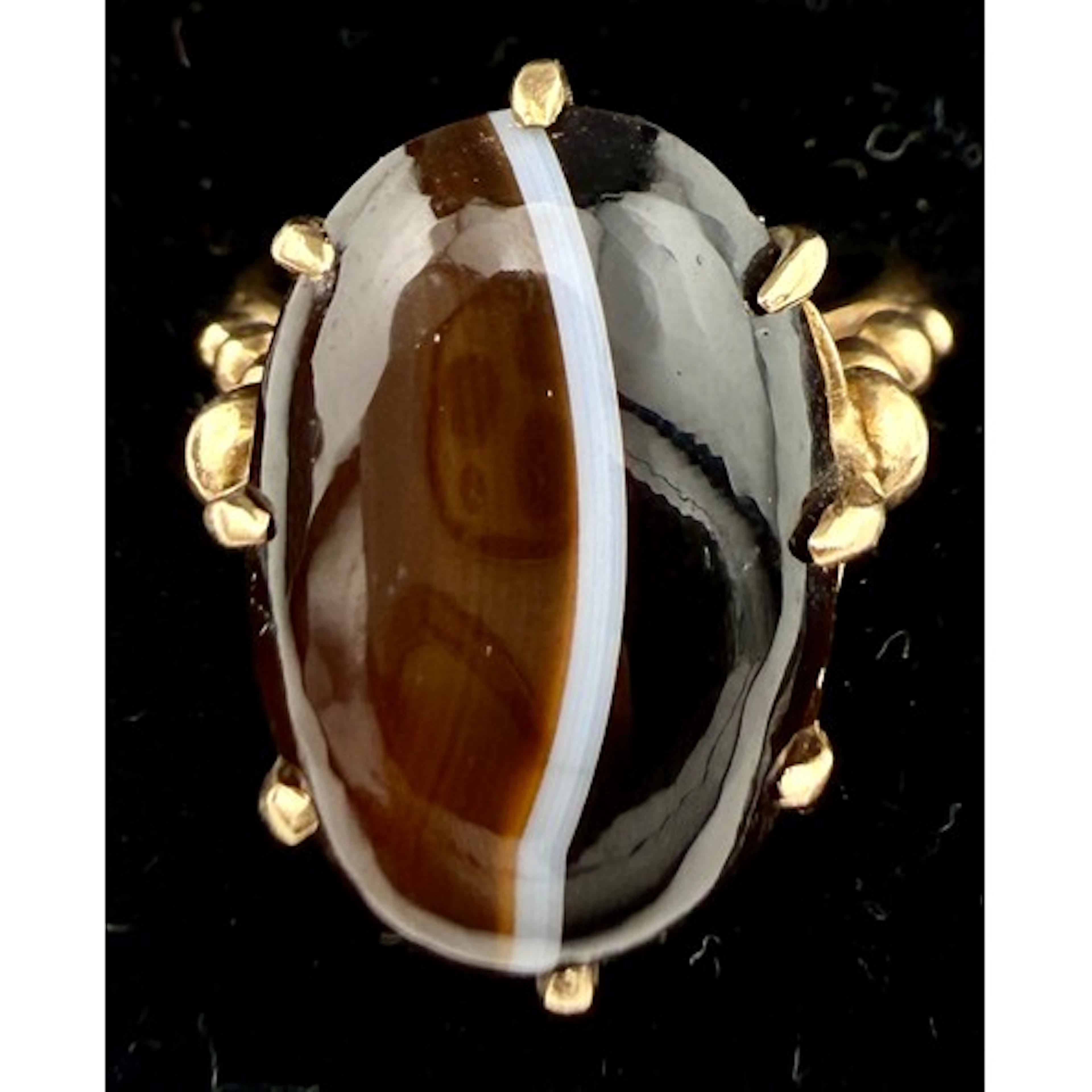 A banded agate ring set in 9 carat gold. Size M. Weight 4.8g...