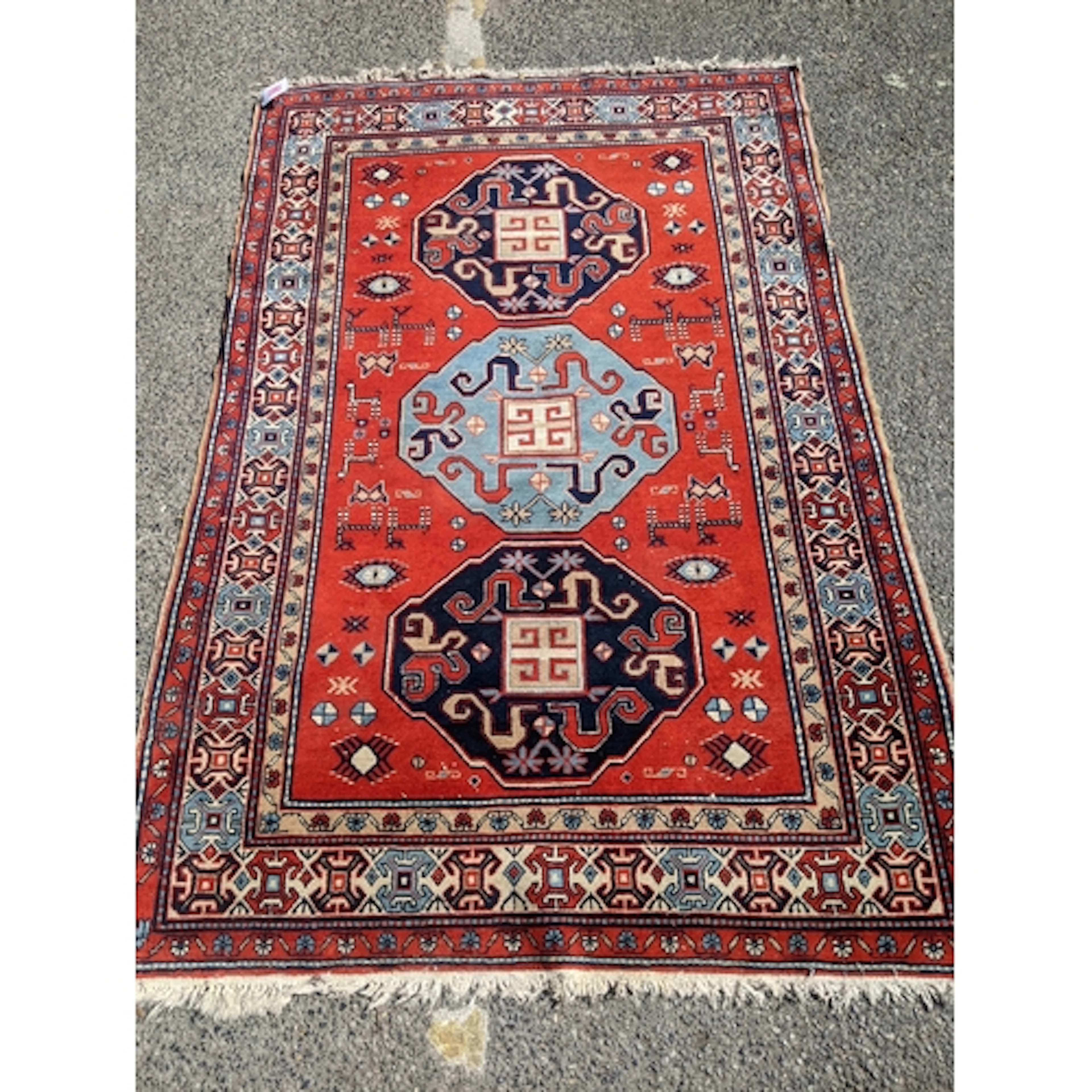 A vintage hand woven Caucasian rug, three central elephant g...
