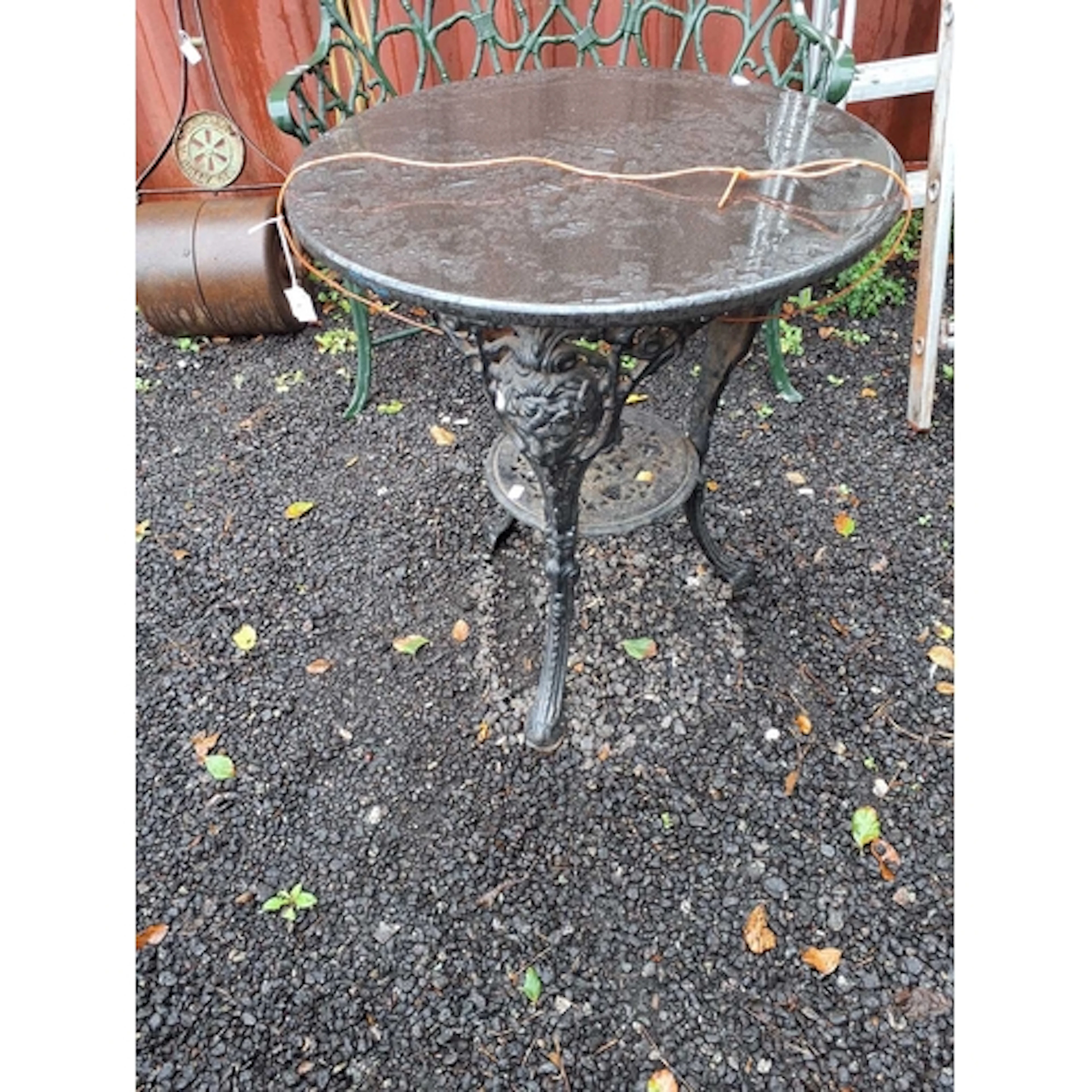 A CAST IRON PUB TABLE with male mask bosses on the legs and ...