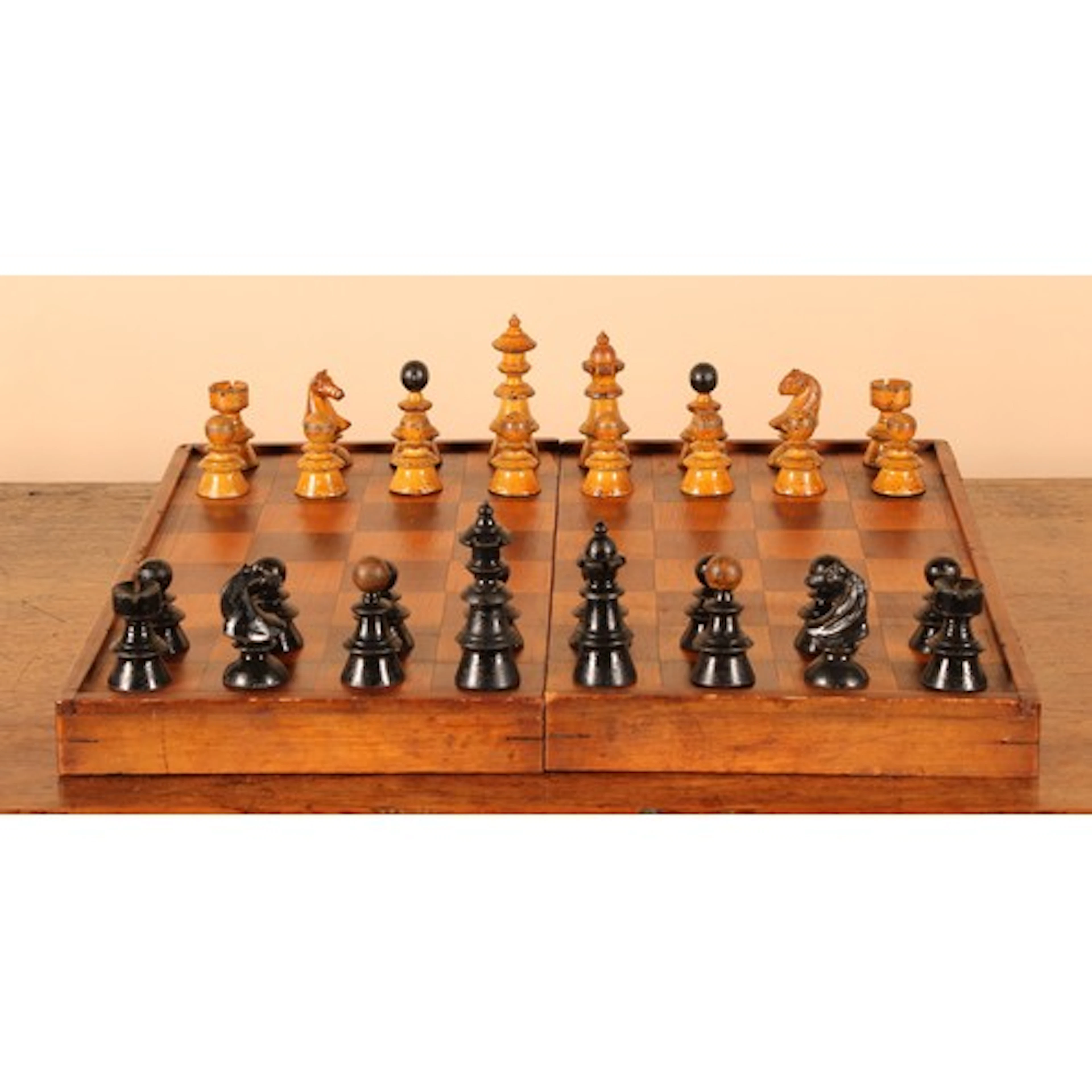 An early 20th century chess set, the folding fruitwood chess...