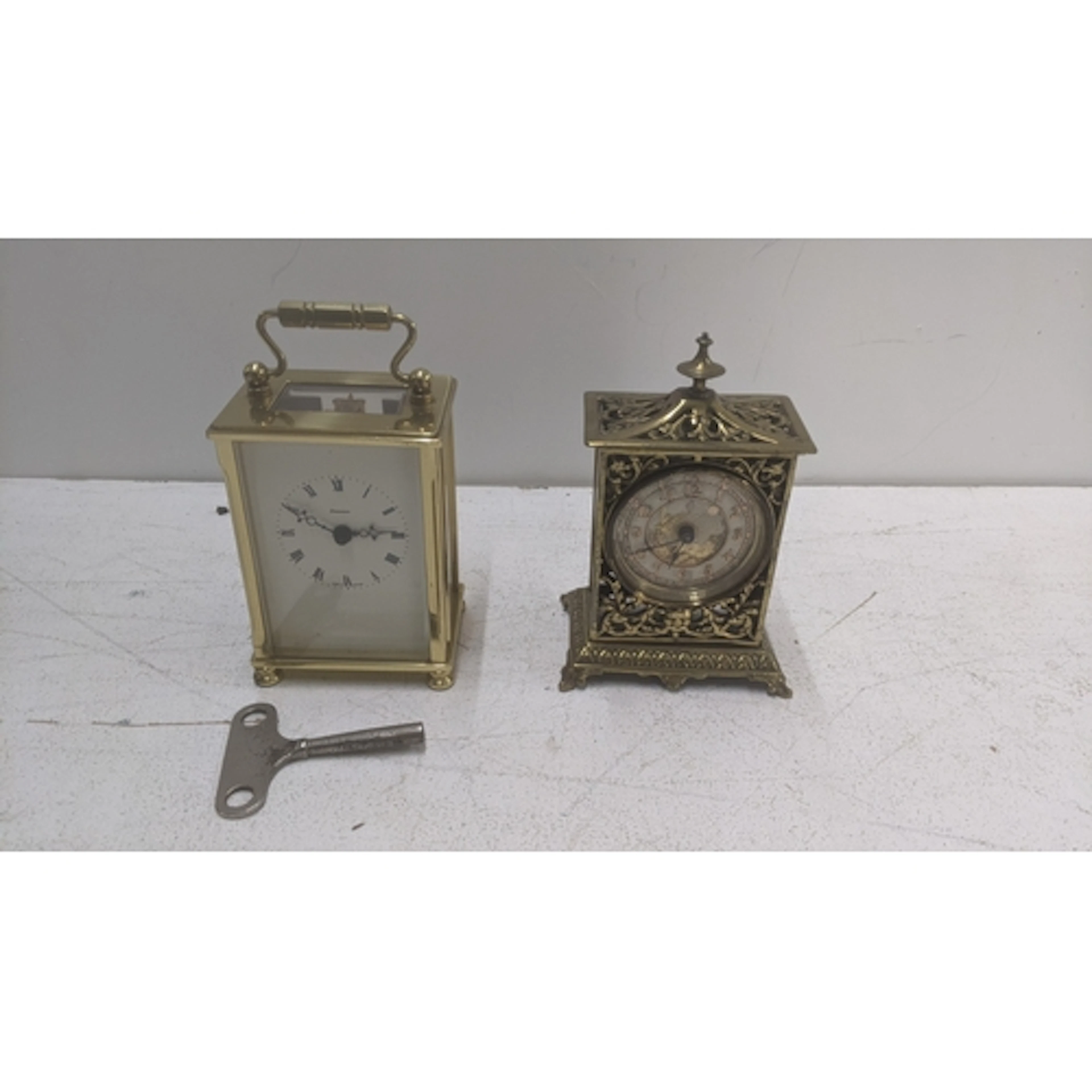 A vintage brass desk clock featuring an intricate fretwork d...