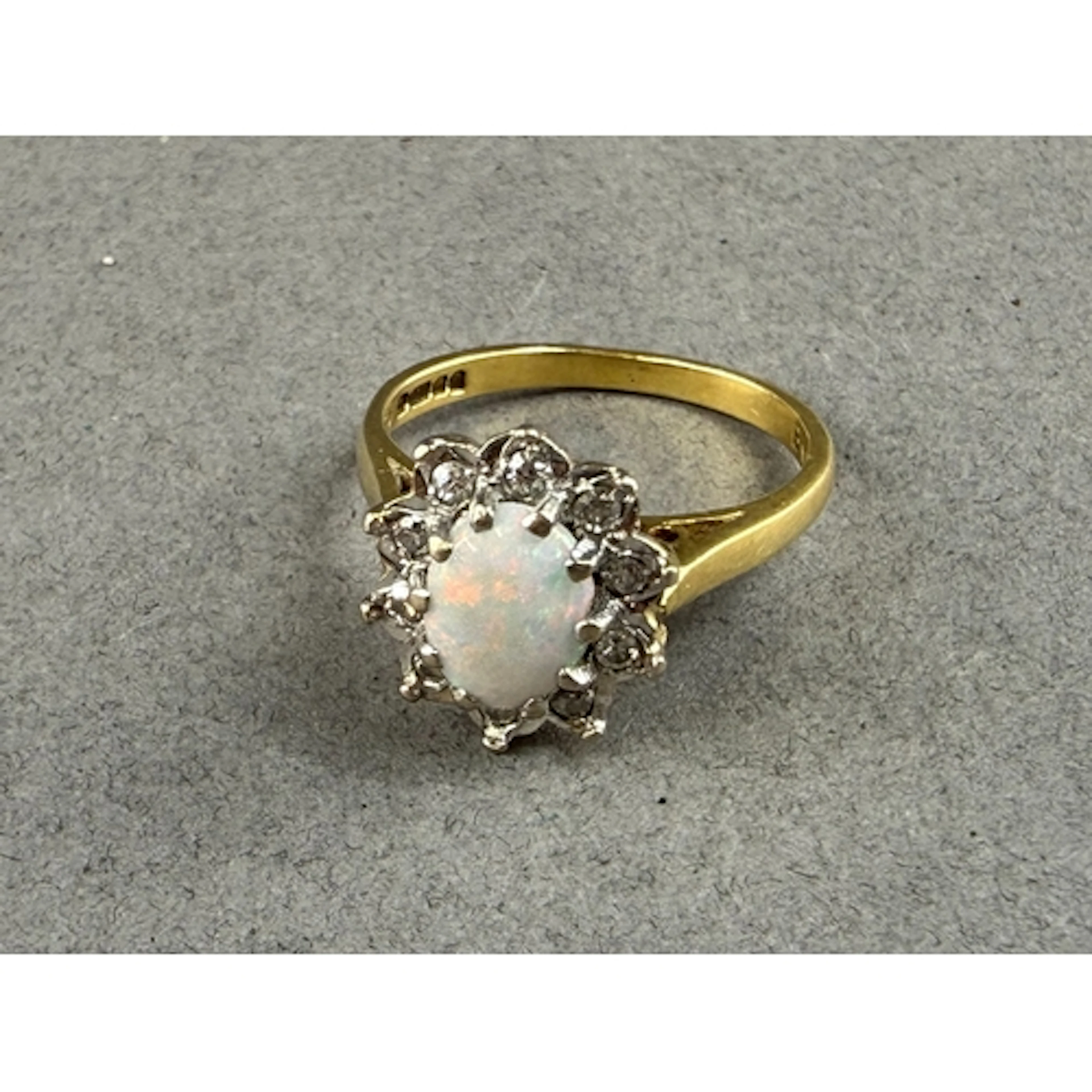 Jewellery: an 18ct yellow gold, opal and diamond cluster rin...