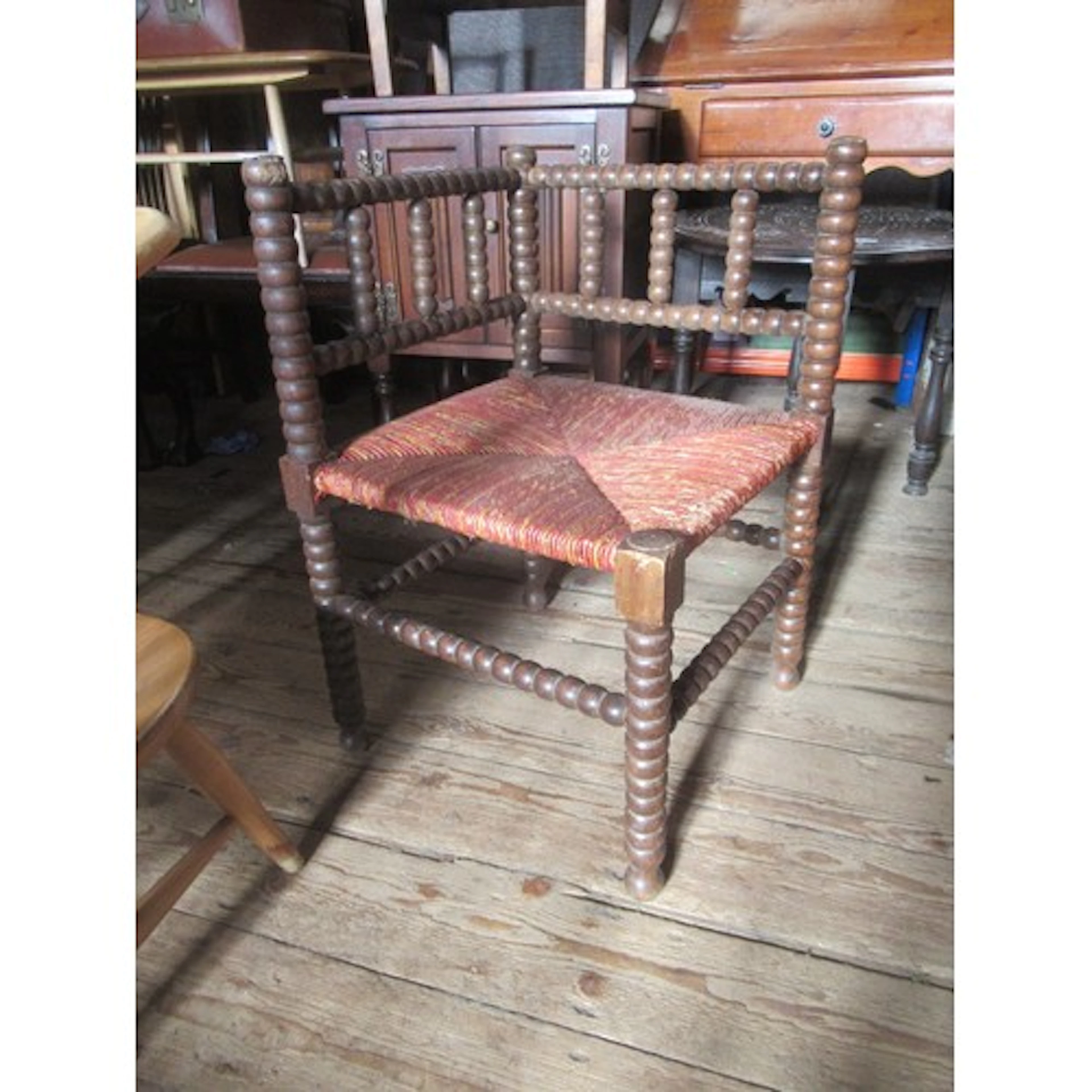 An antique style oak corner chair with bobbin turned decorat...