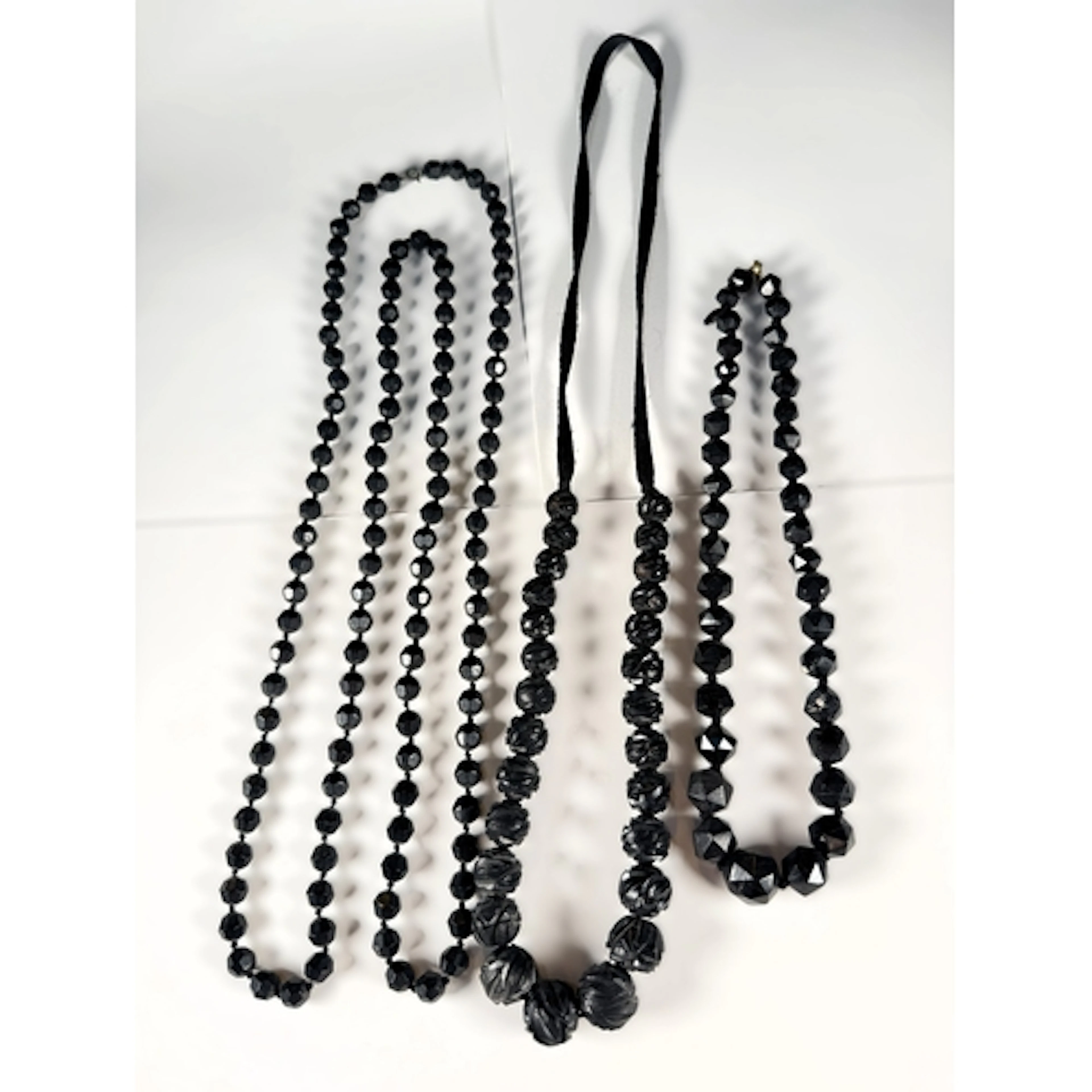 A vintage carved graduating jet bead necklace; 2 similar fac...
