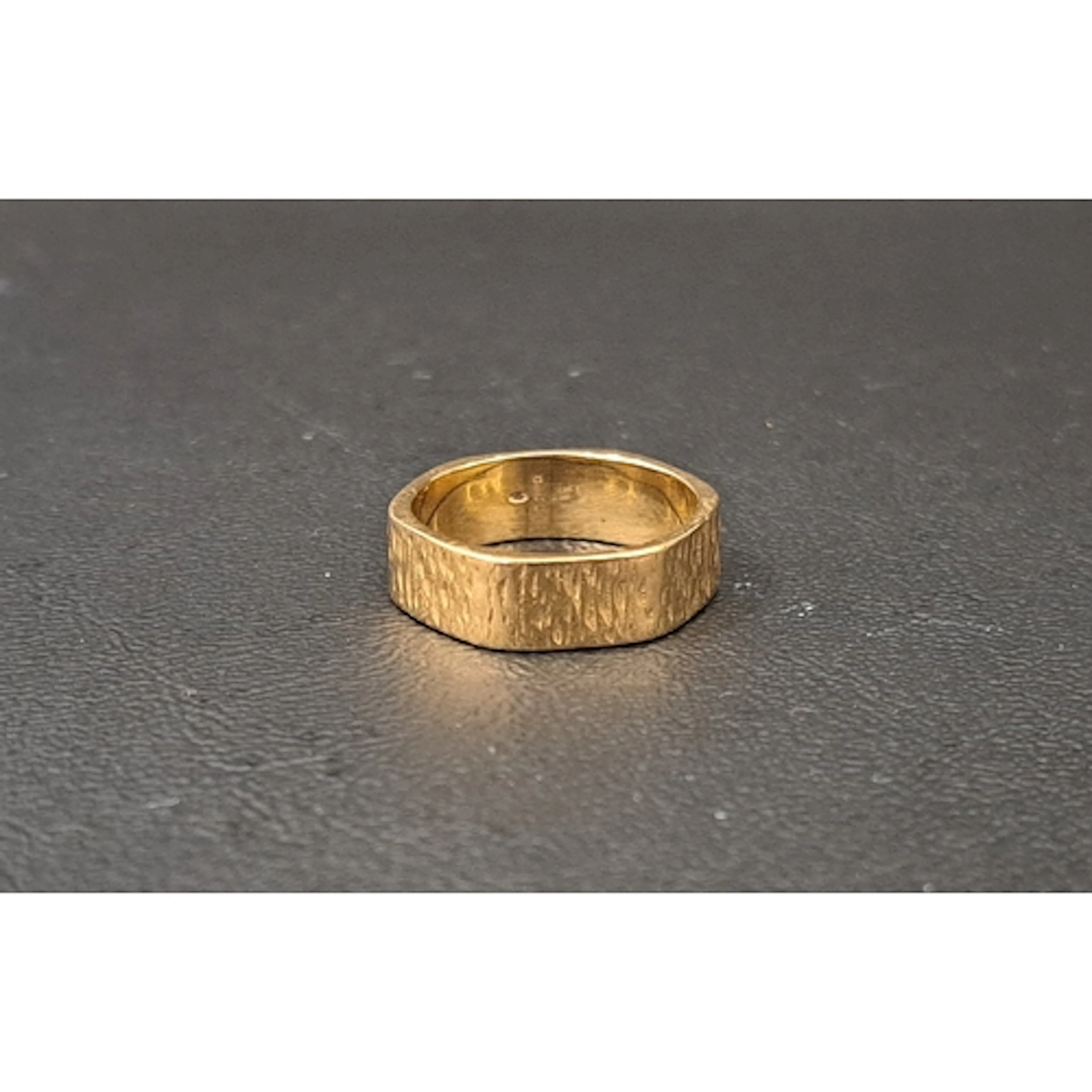 NINE CARAT GOLD RING the hexagonal ring with textured finish...