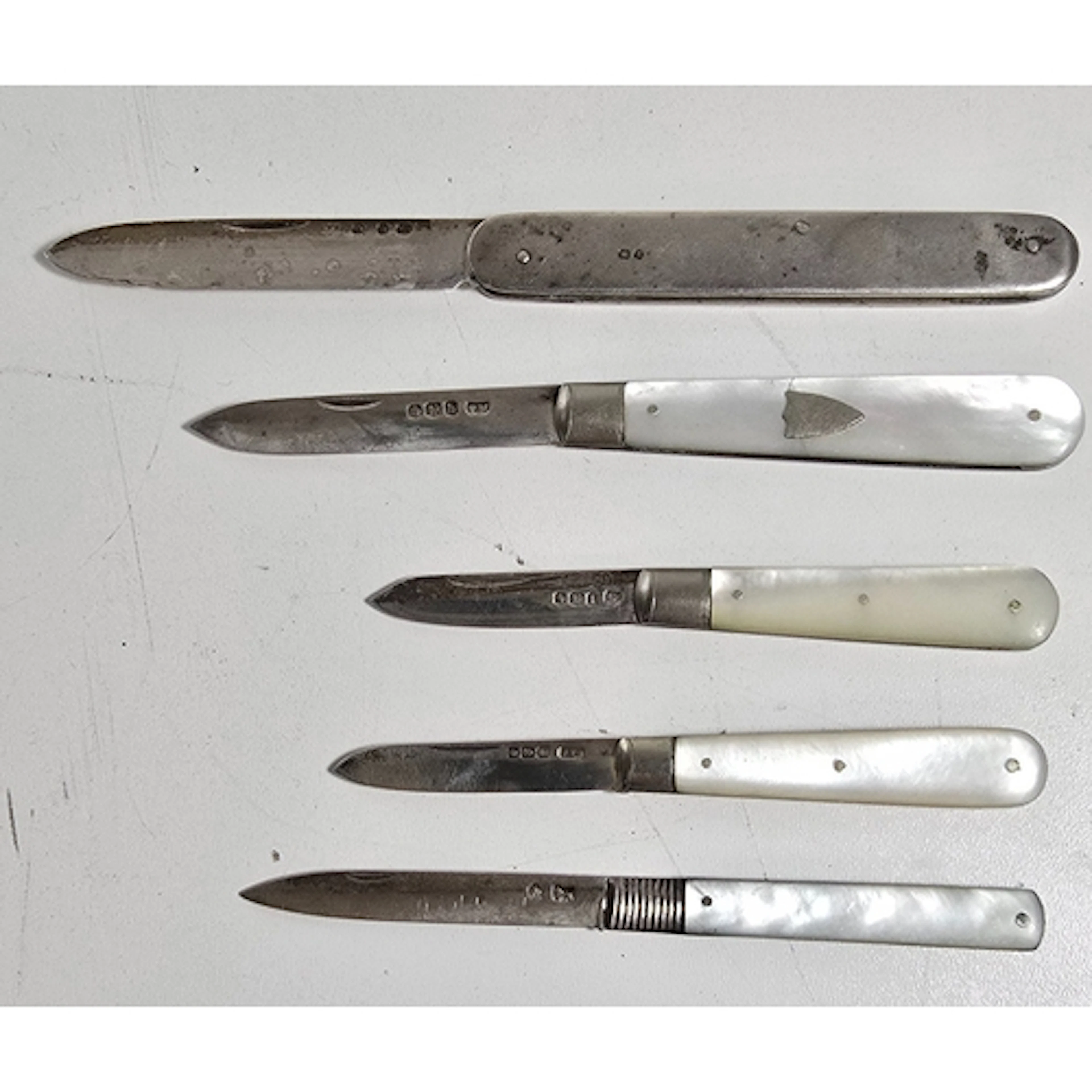 Four folding fruit knives with silver blades, three with She...