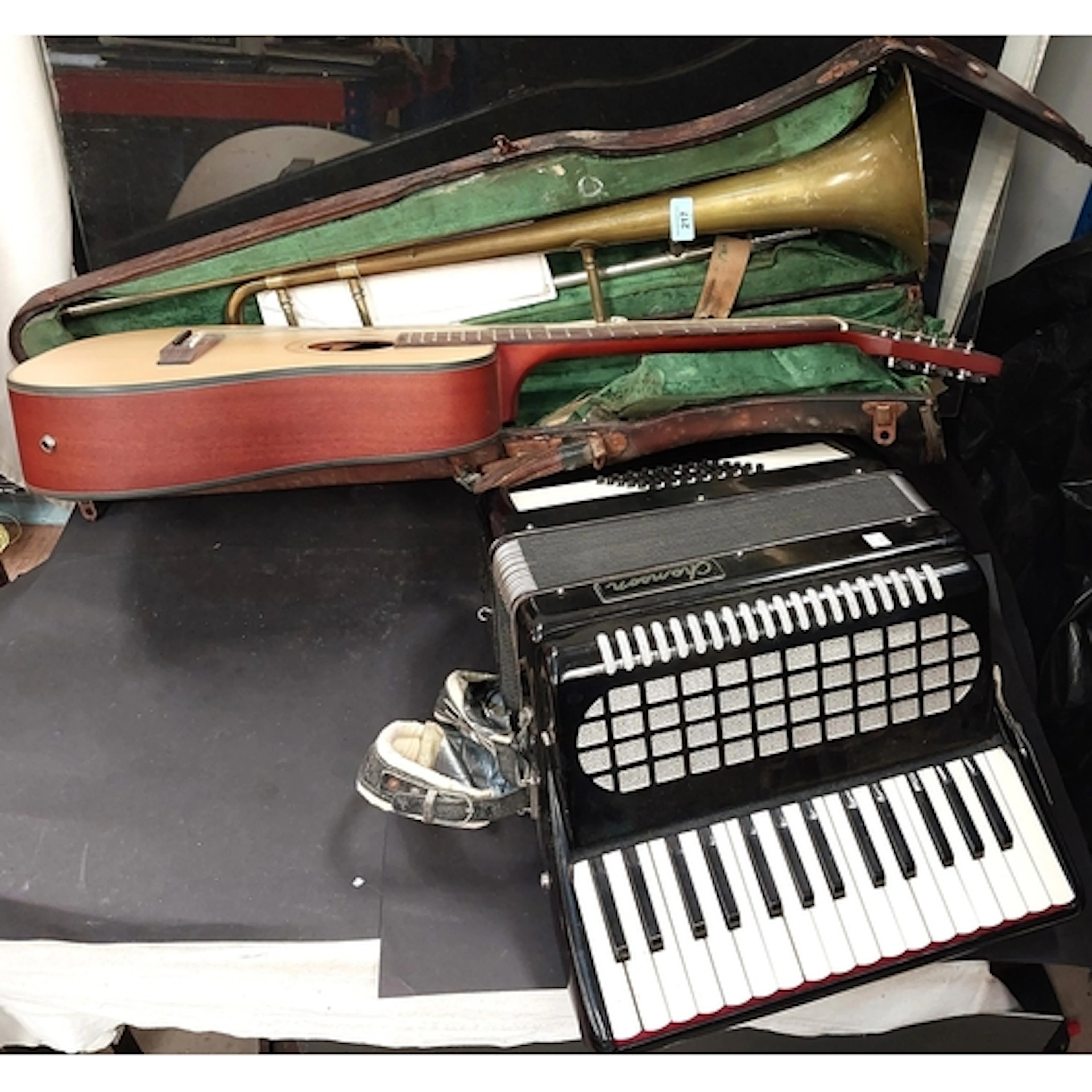 A vintage Academy 403 trombone, an Encore acoustic guitar an...