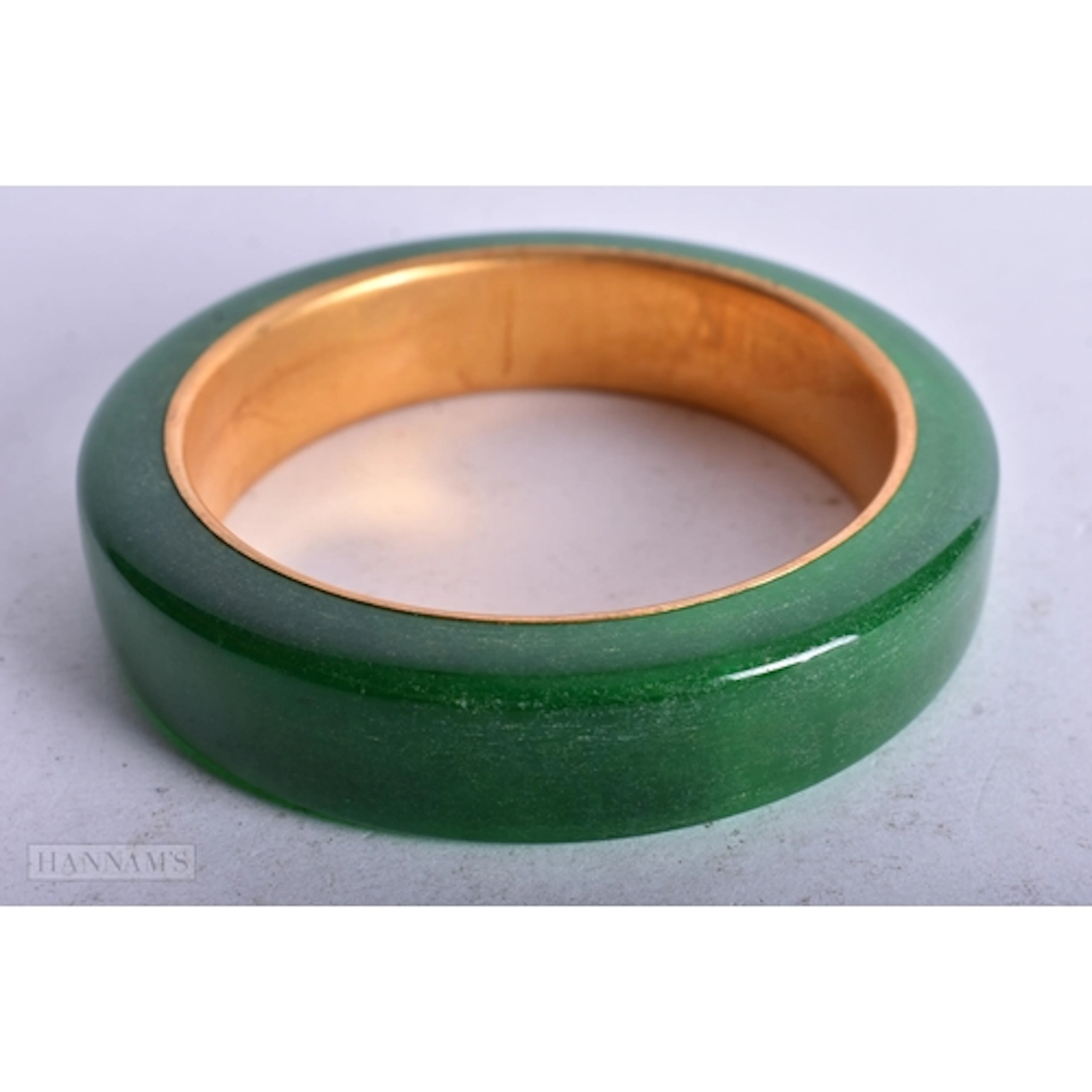 A CHINESE GOLD LINED GREEN JADE BANGLE. 6 cm internal diamet...