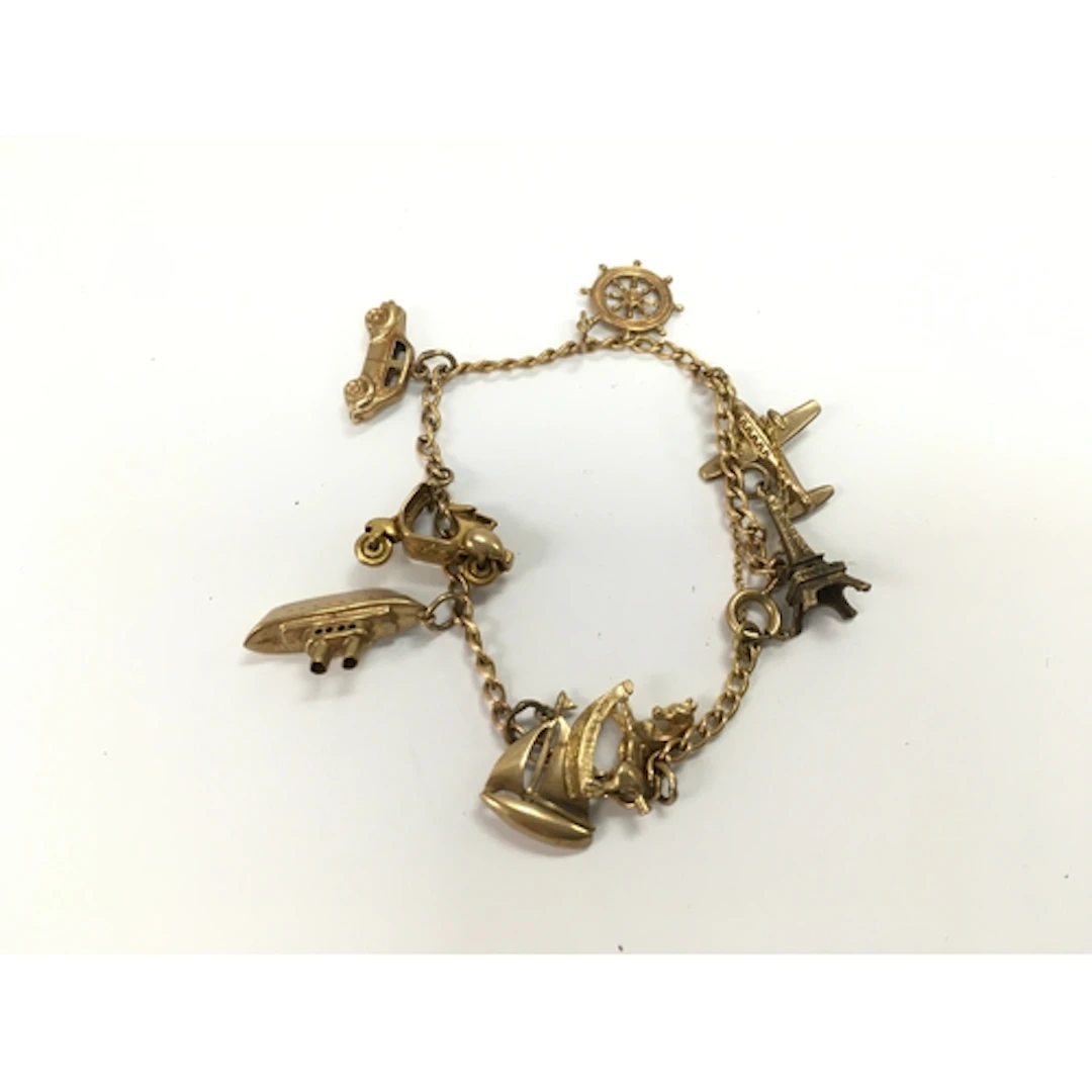A 9ct gold charm bracelet with assorted charms. 12.90g