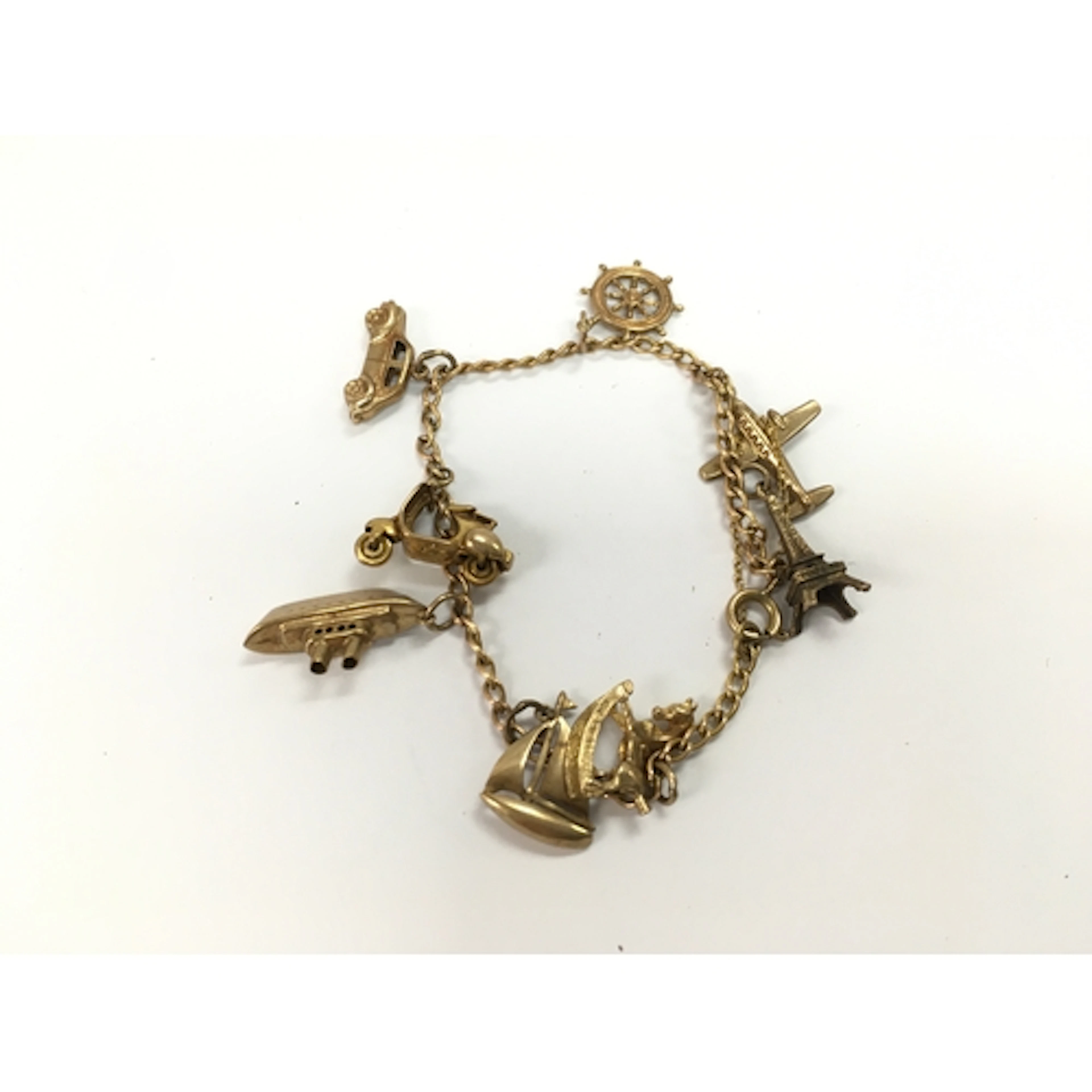 A 9ct gold charm bracelet with assorted charms. 12.90g