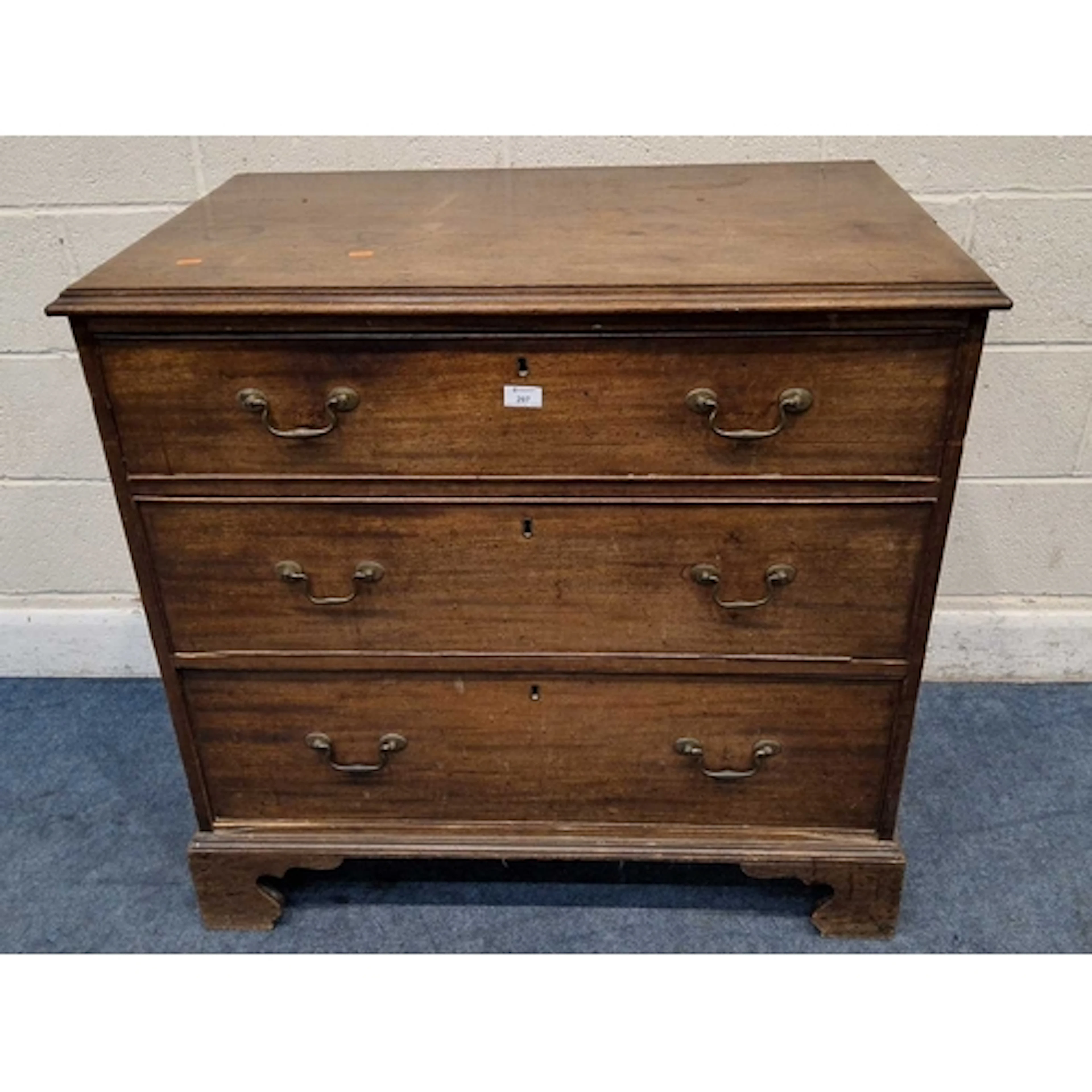 A GEORGIAN MAHOGANY CHEST OF THREE GRADUATED DRAWERS, raised...