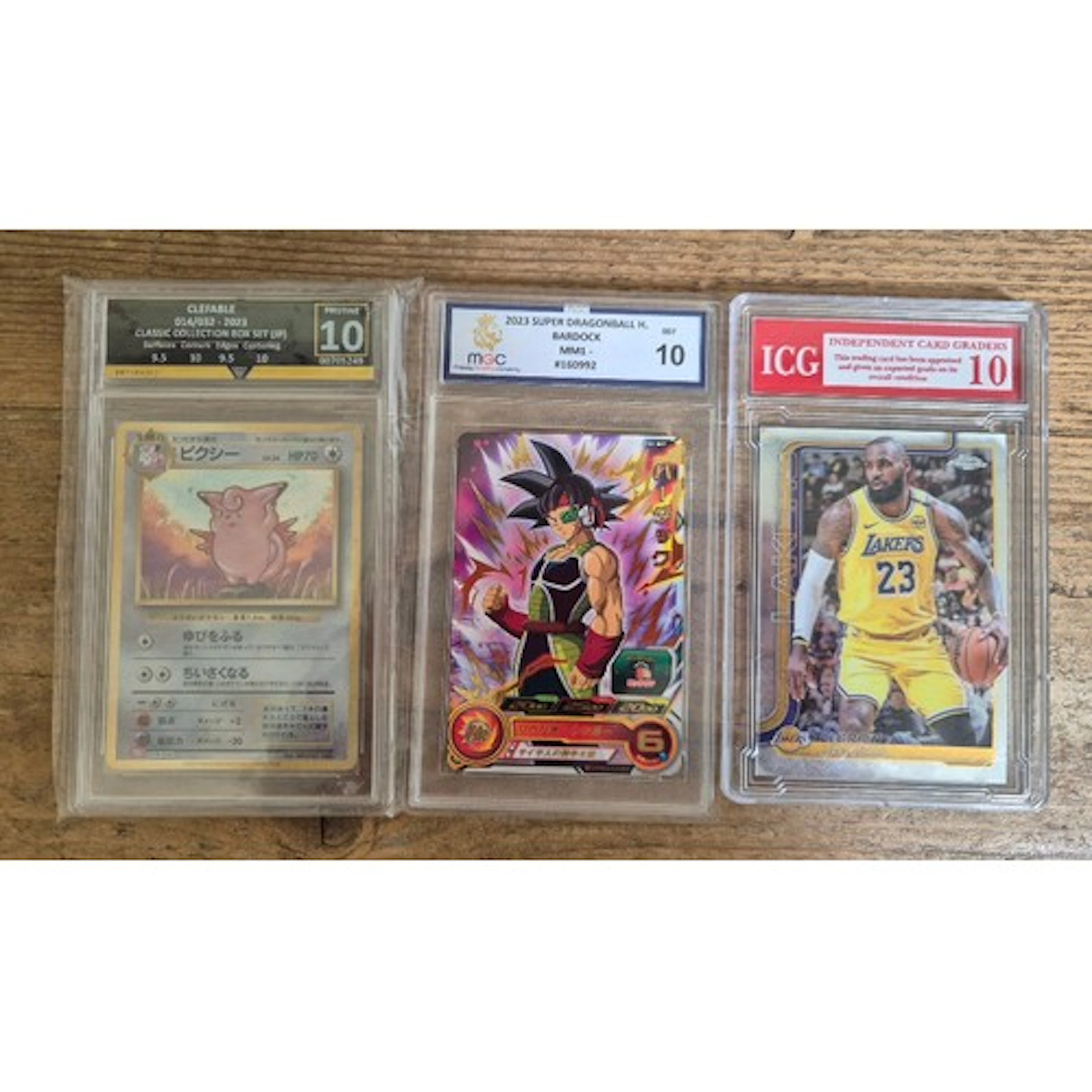 A group of three graded collector cards in plastic slabs com...
