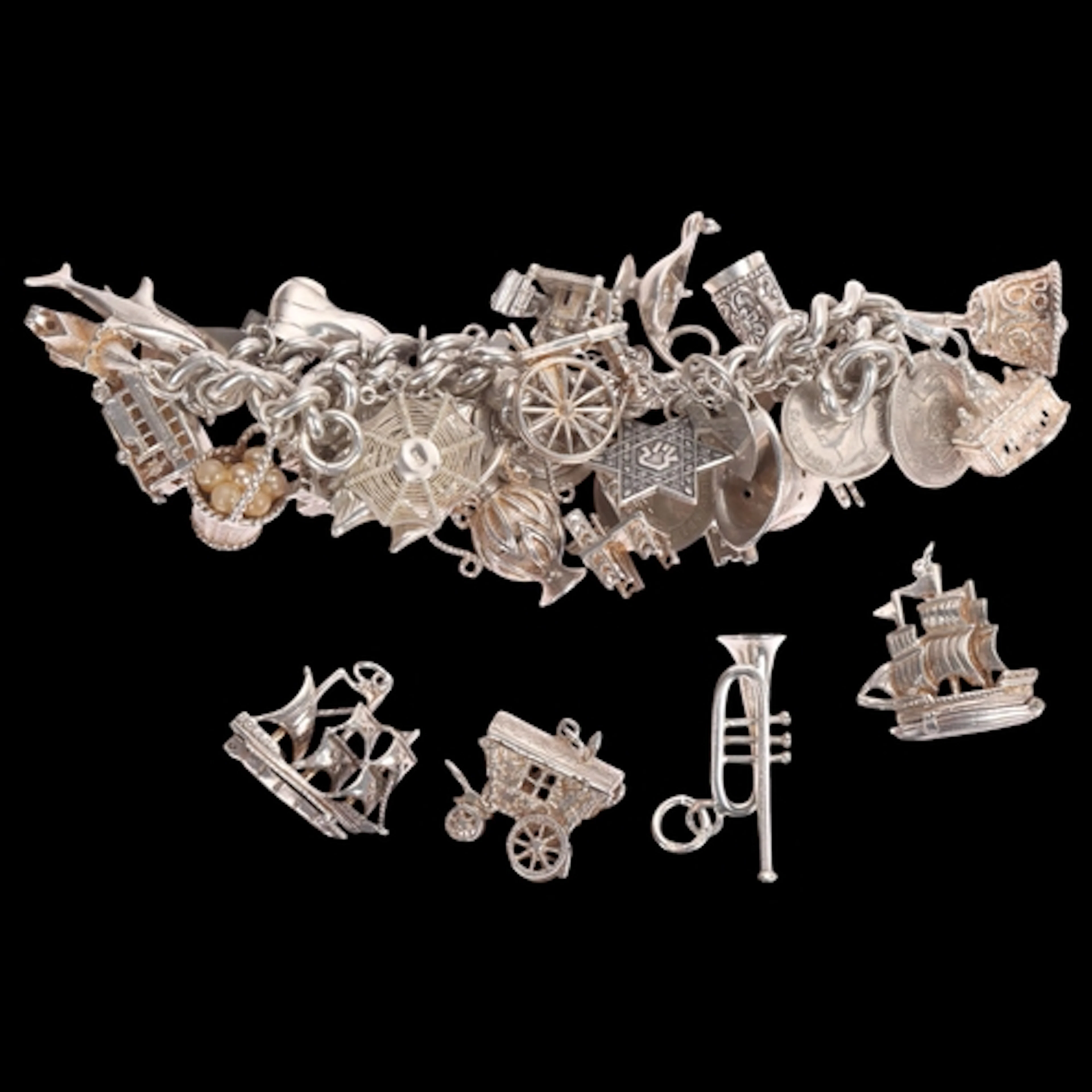 A heavy silver charm bracelet, with various silver charms, 1...