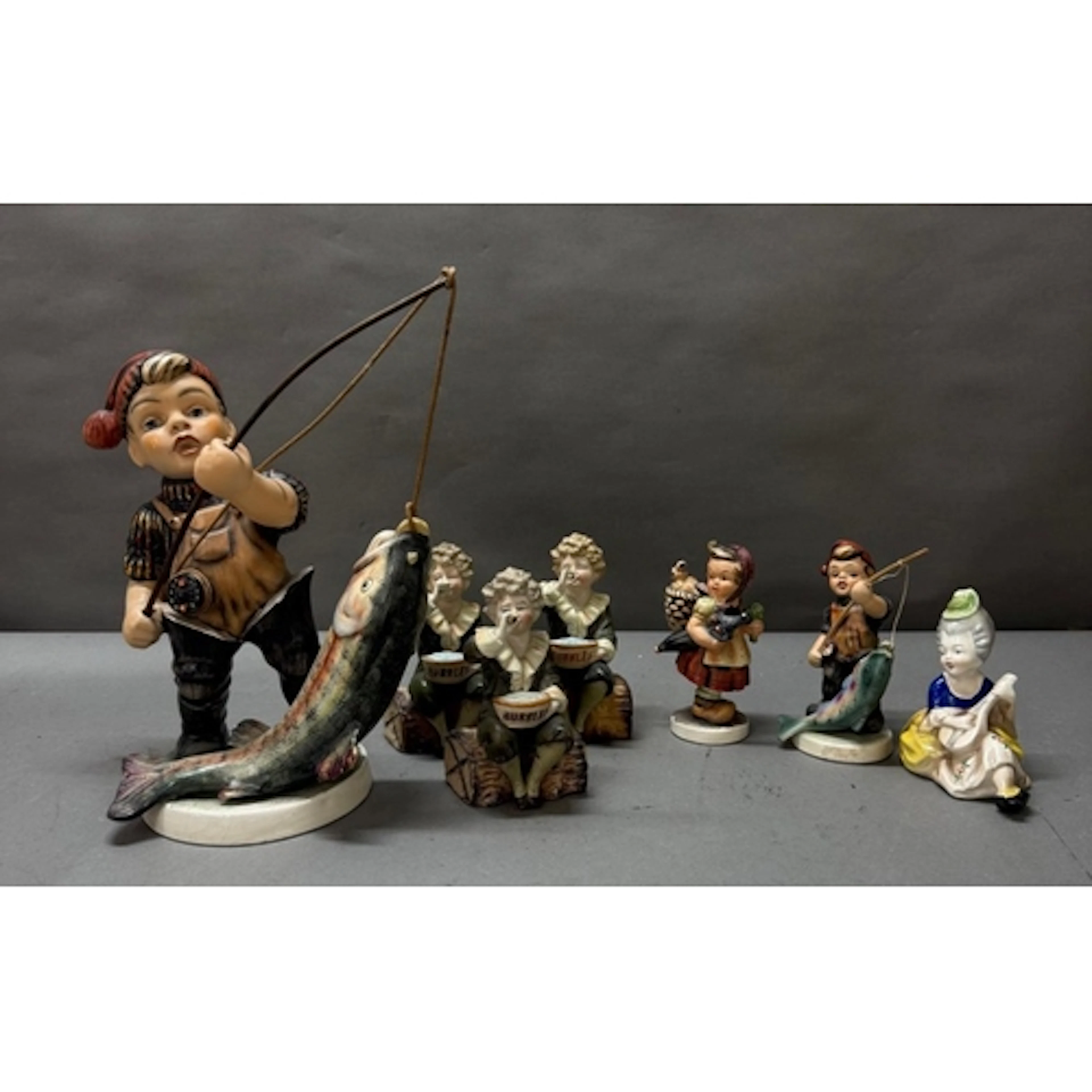 A selection of bisque figurines in the style of Hummel. Vari...