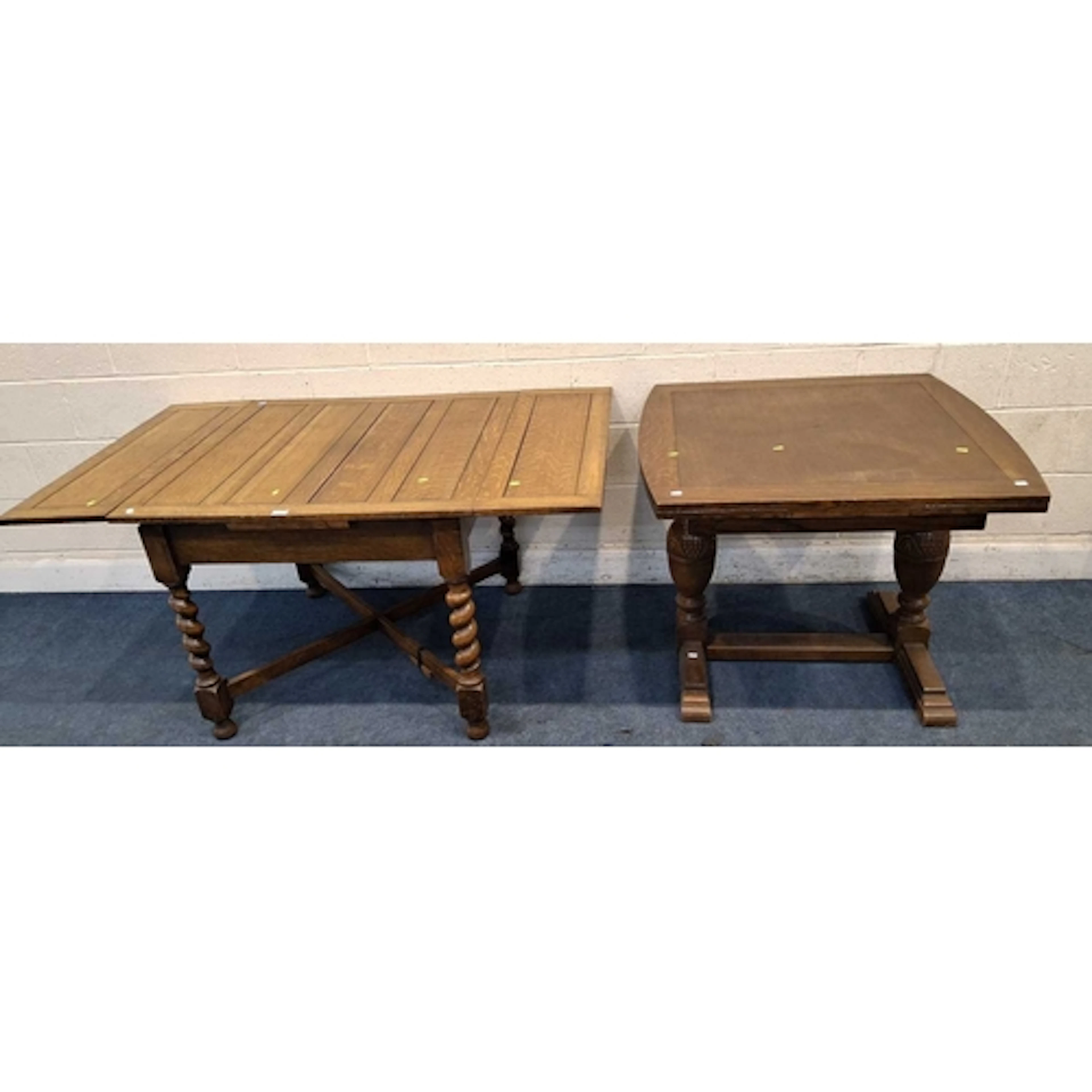 TWO EARLY 20TH CENTURY OAK DRAW LEAF DINING TABLES, one rais...