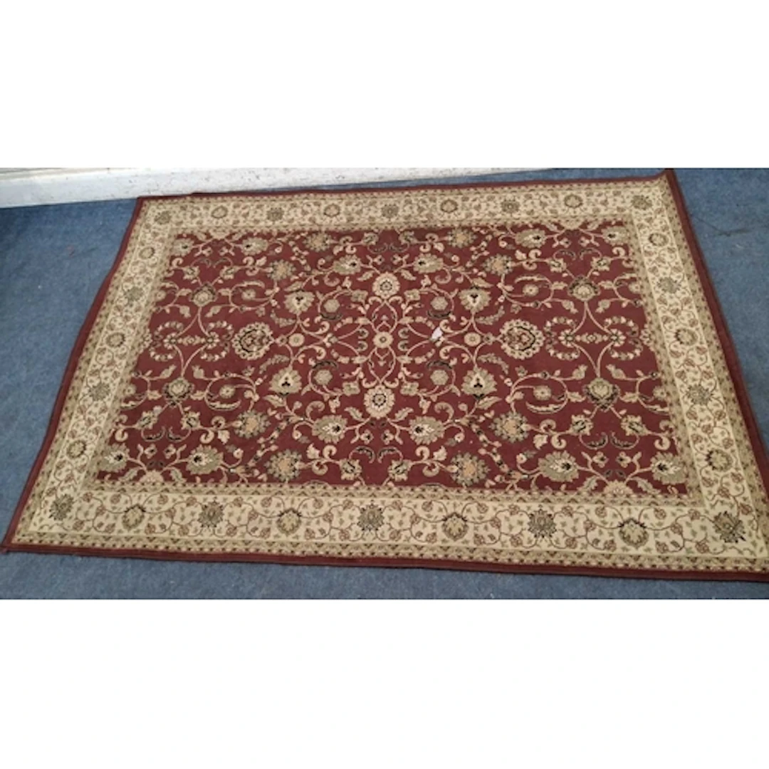 A RED GROUND RECTANGULAR 100% POLYPROPYLENE RUG, with repeat...