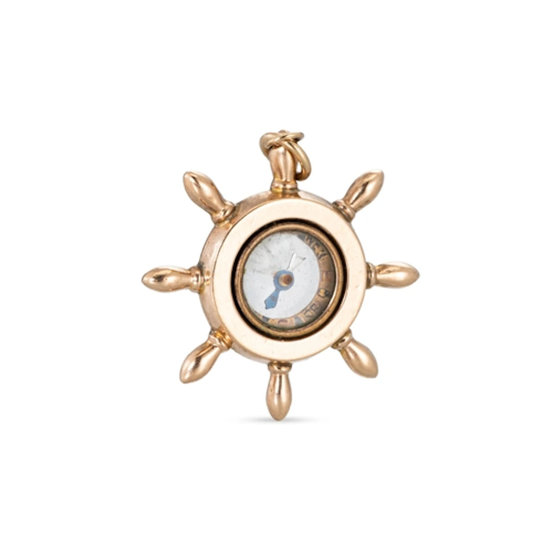 A 9CT GOLD NAUTICAL PENDANT, modelled as a ship's wheel & co...