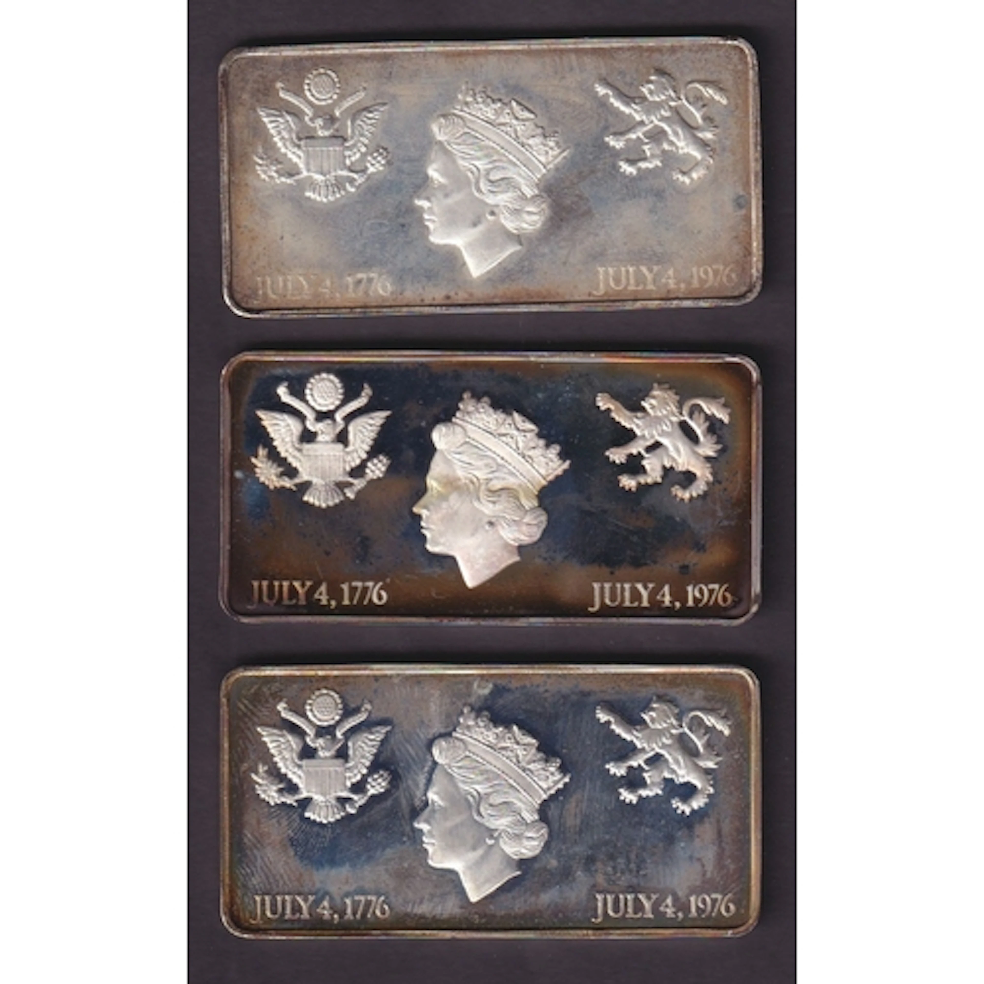 A group of three sterling silver ingots commemorating the 19...