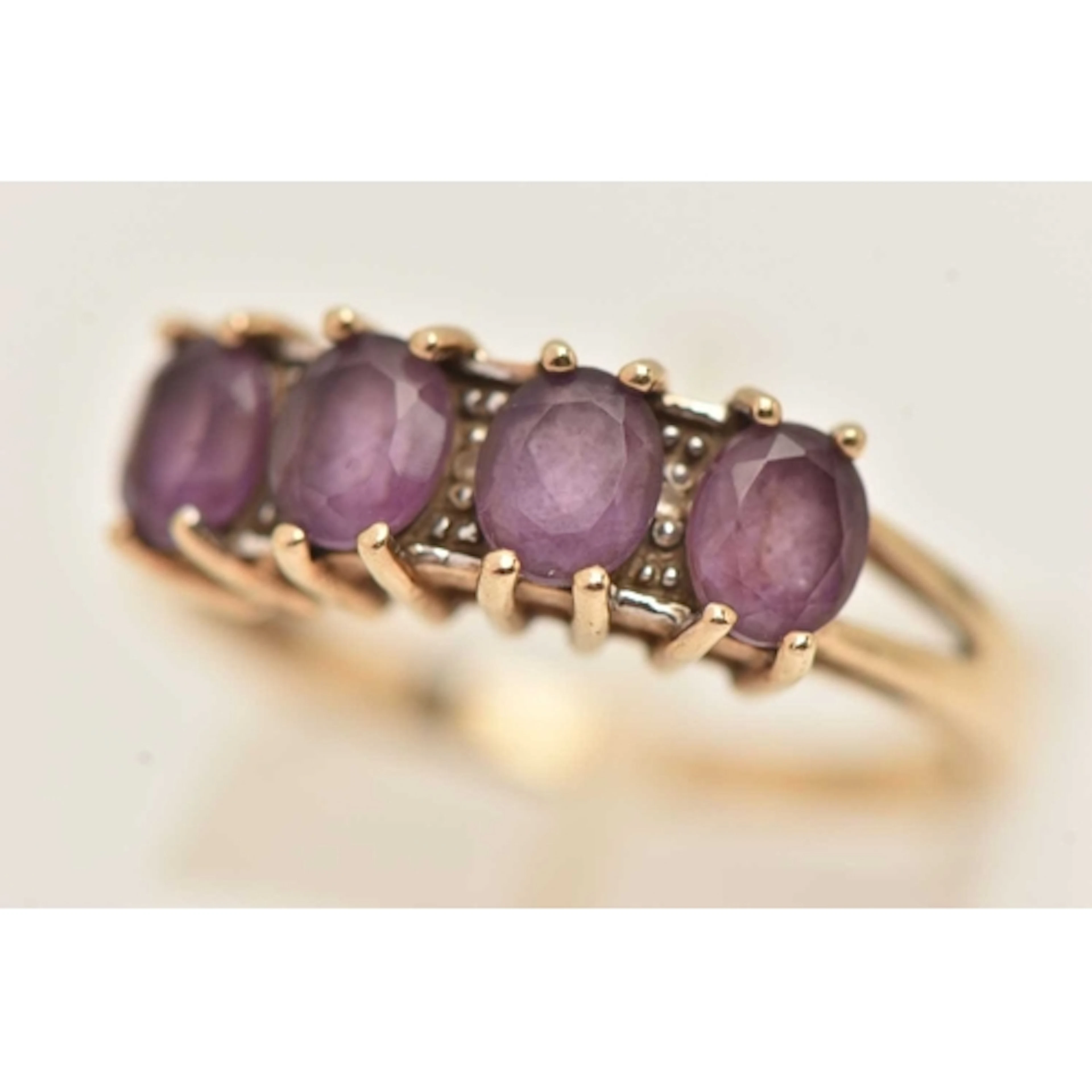 A 9CT YELLOW GOLD GEM SET RING, four oval cut amethysts, acc...