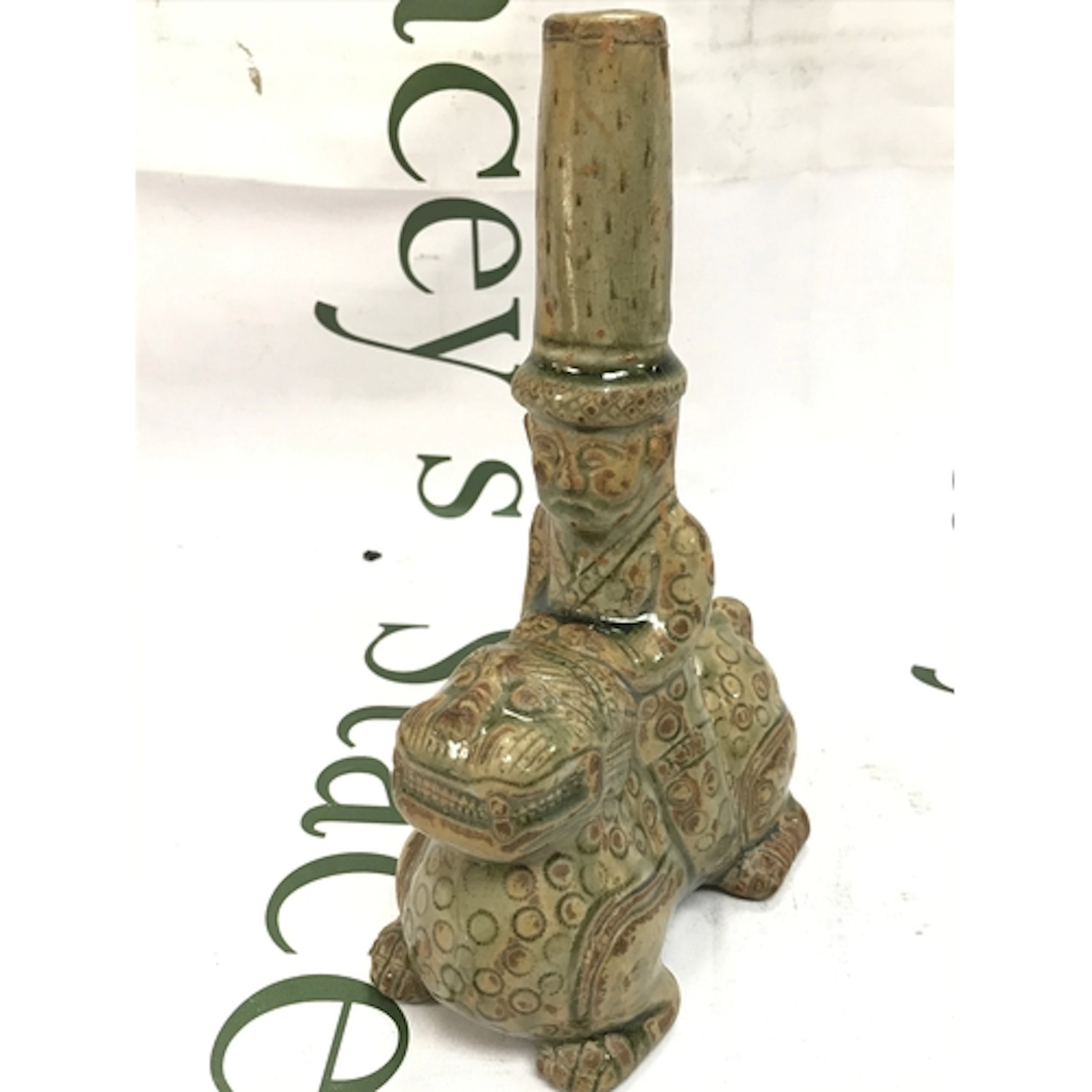 A Chinese ceramic figurine depicting a rider on a mythical b...