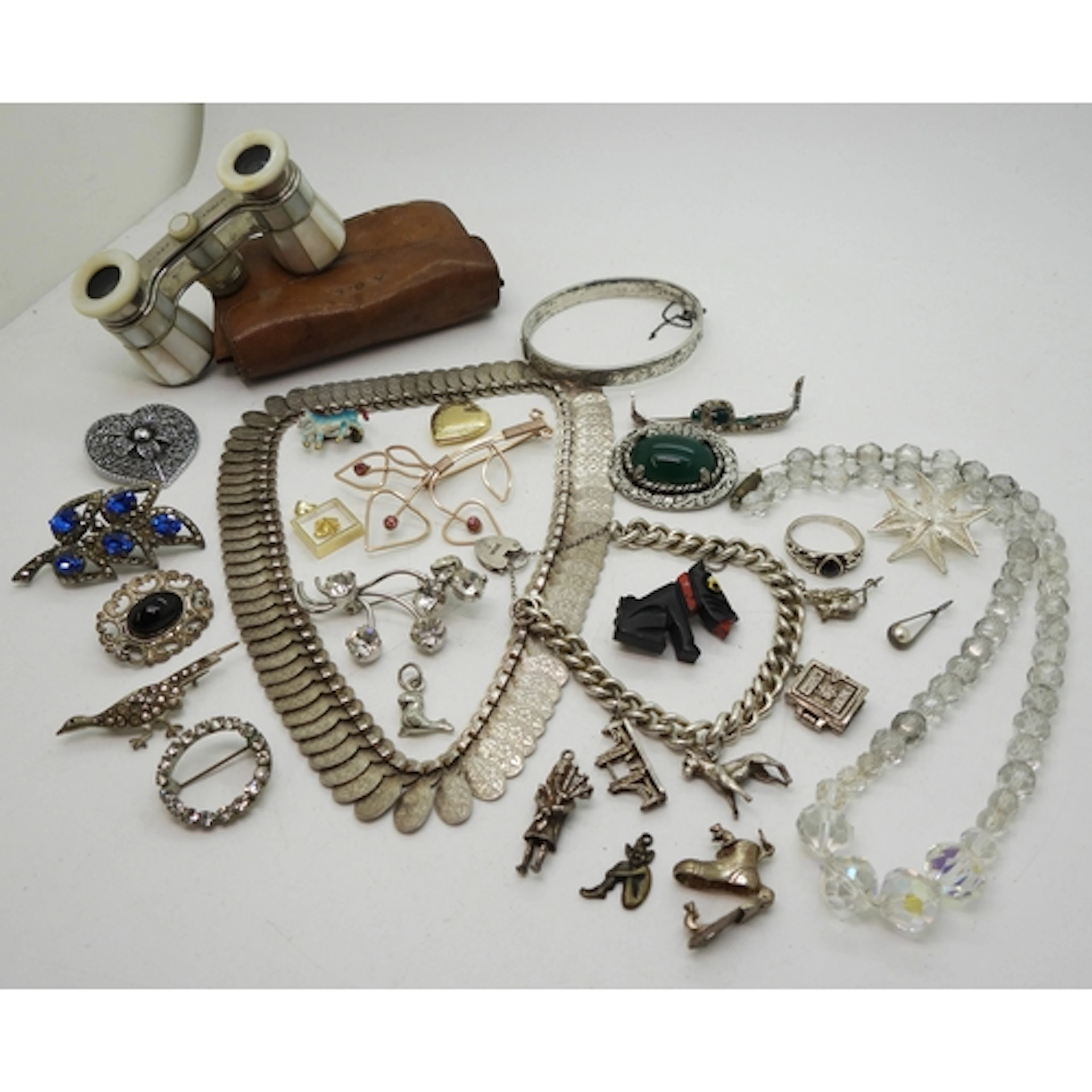 A silver fringe necklace, a silver charm bracelet with heart...