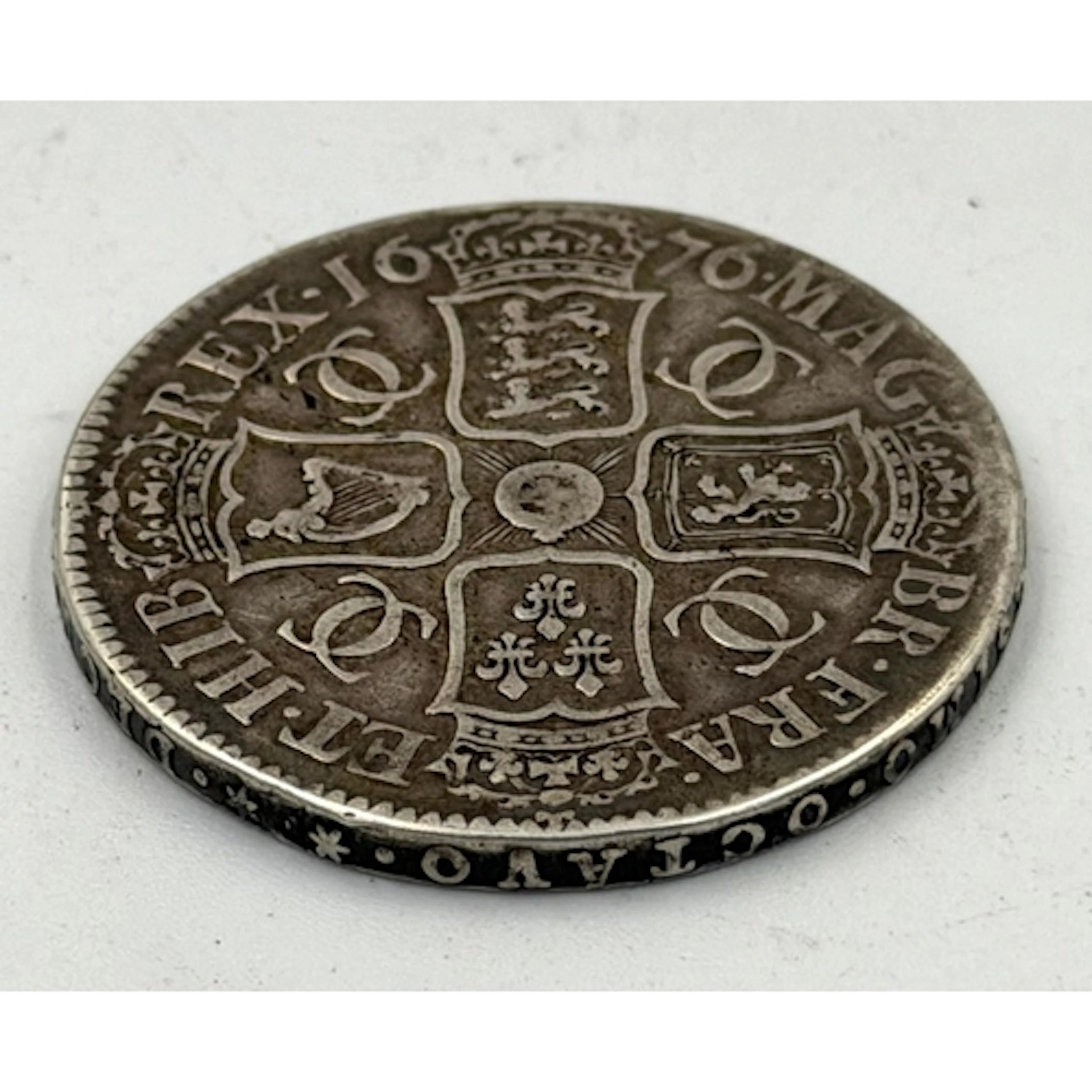 A Charles II silver crown dated 1676.