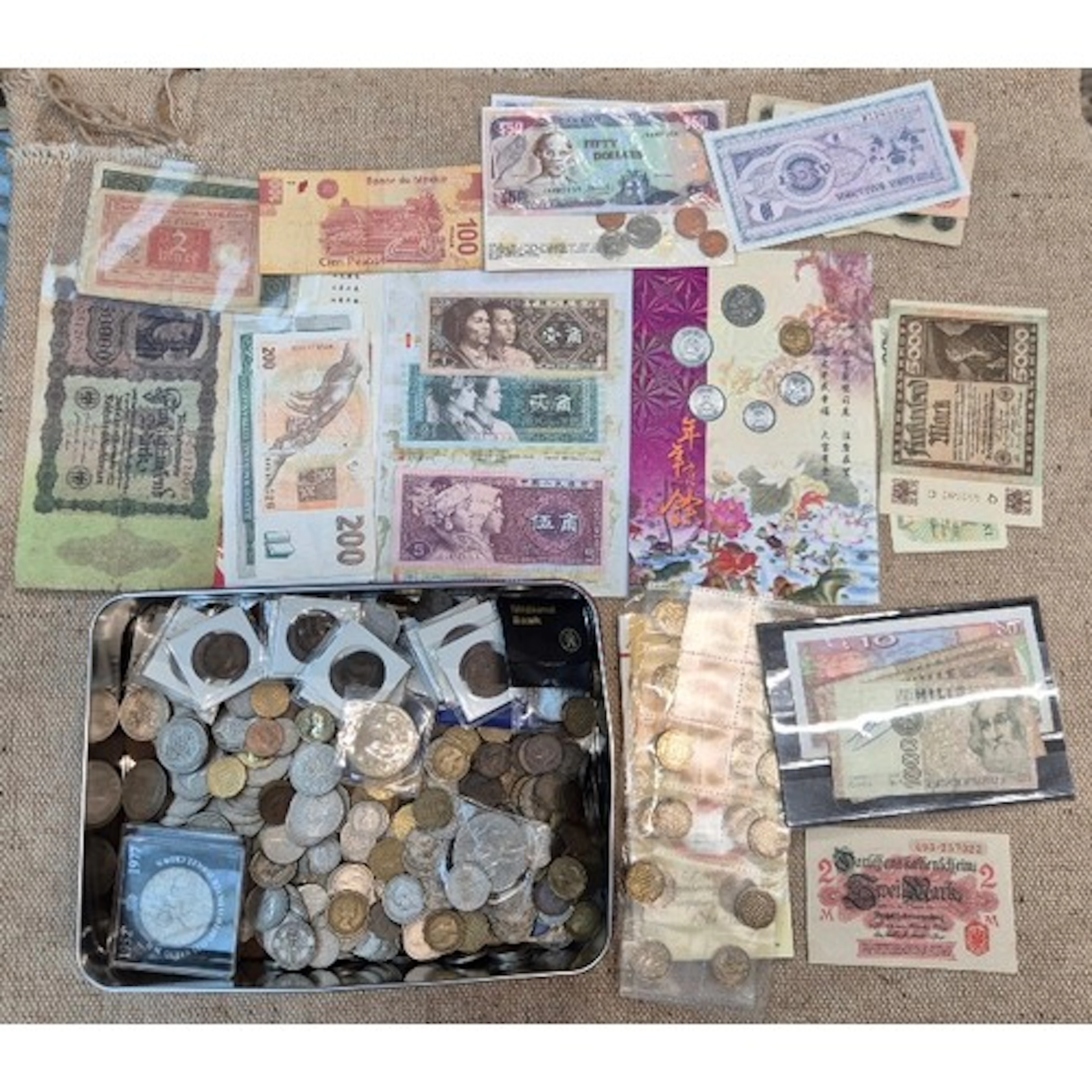 A tin of assorted worlds coins & banknotes to include commem...