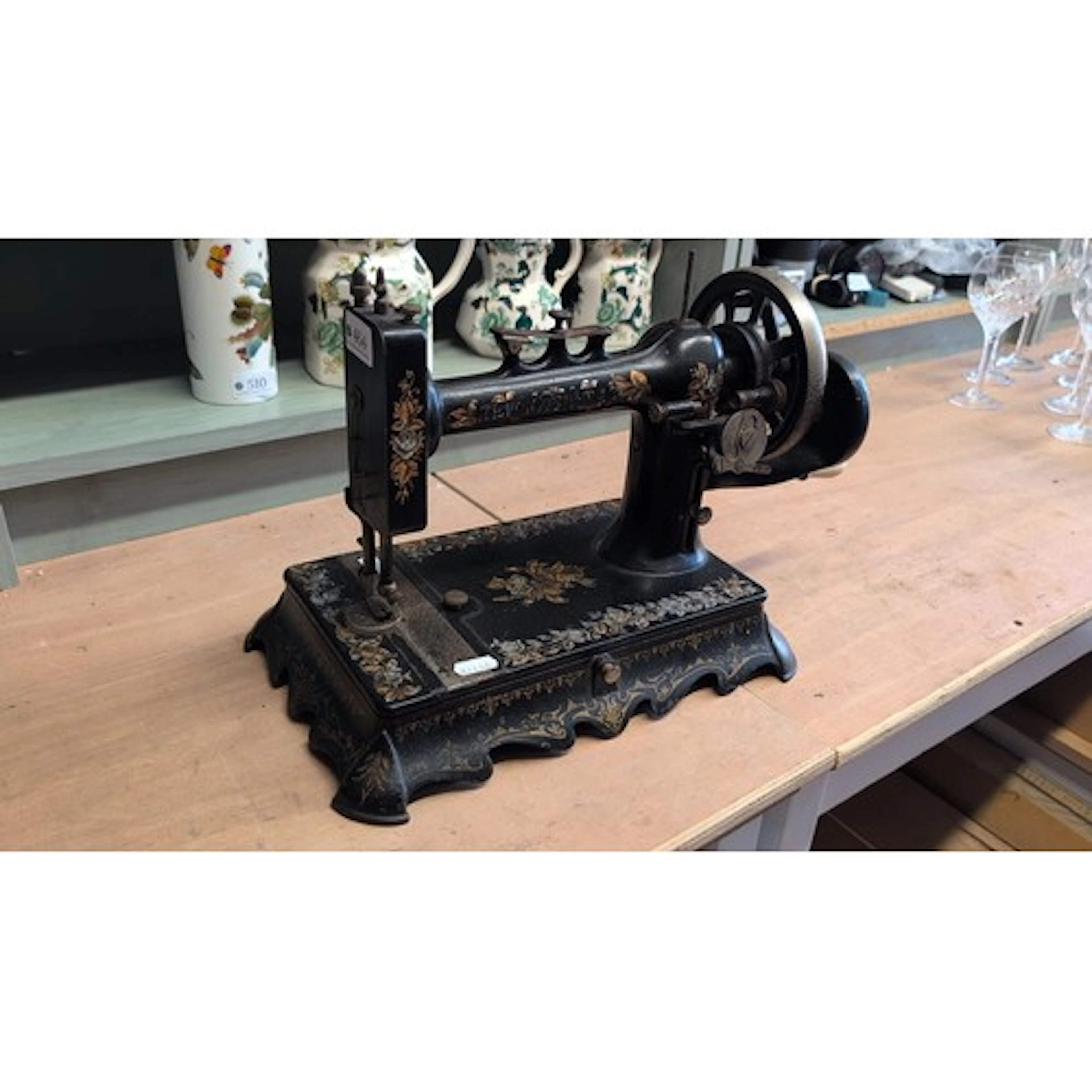 Early 20th century hand-cranked sewing machine with black ja...