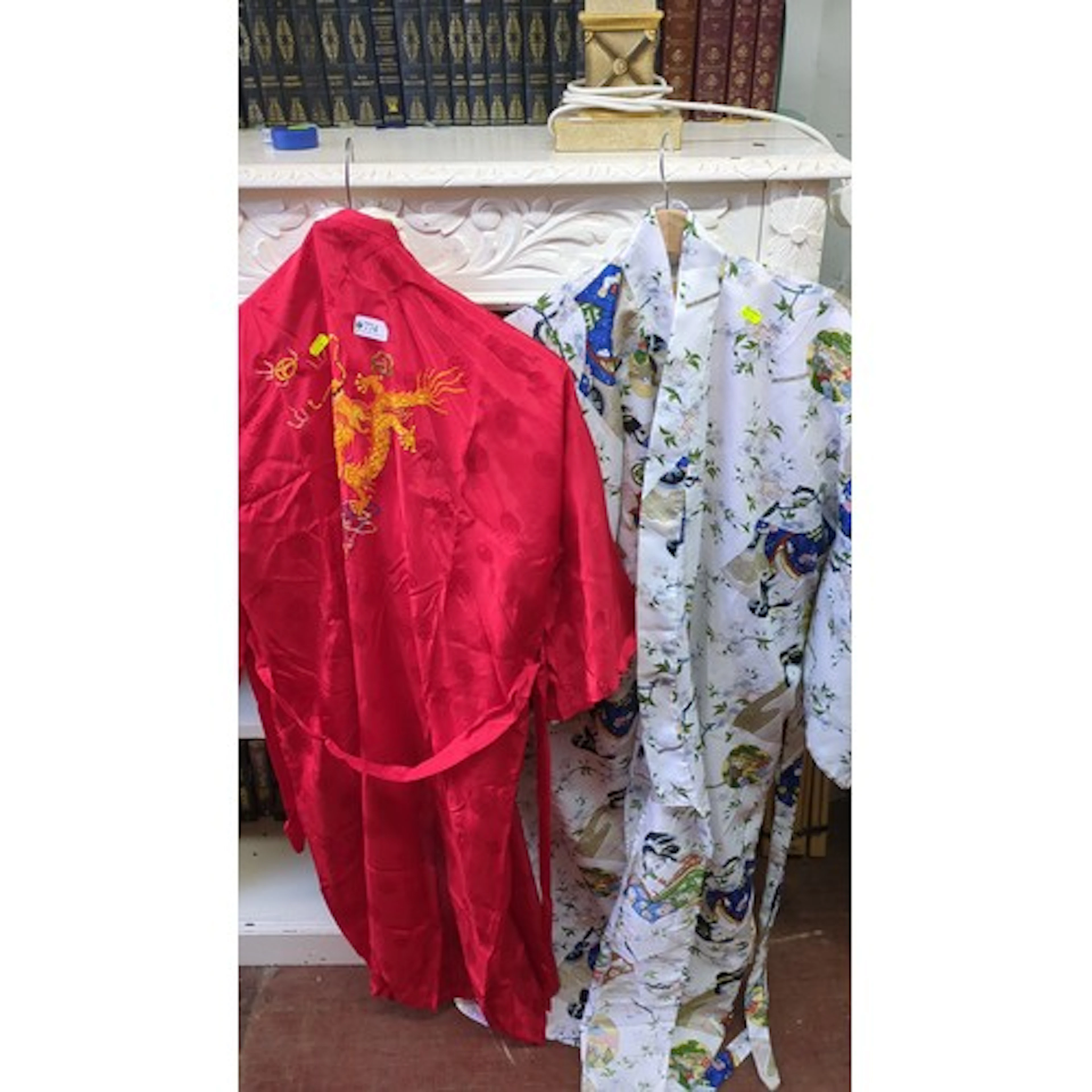 A pair of East Asian-style satin robes, one in red damask wi...