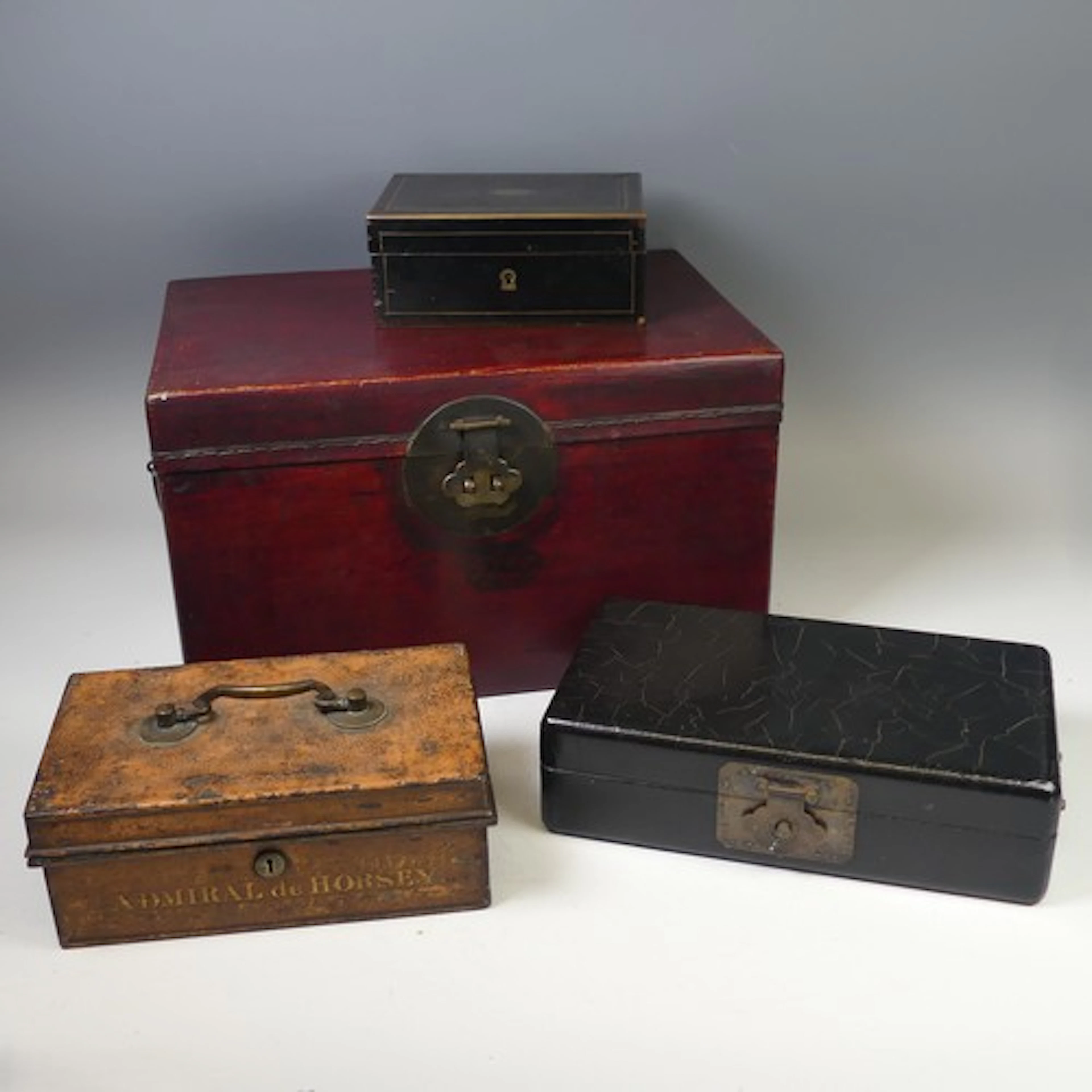 An antique Chinese red leather Box, with swing handles and t...