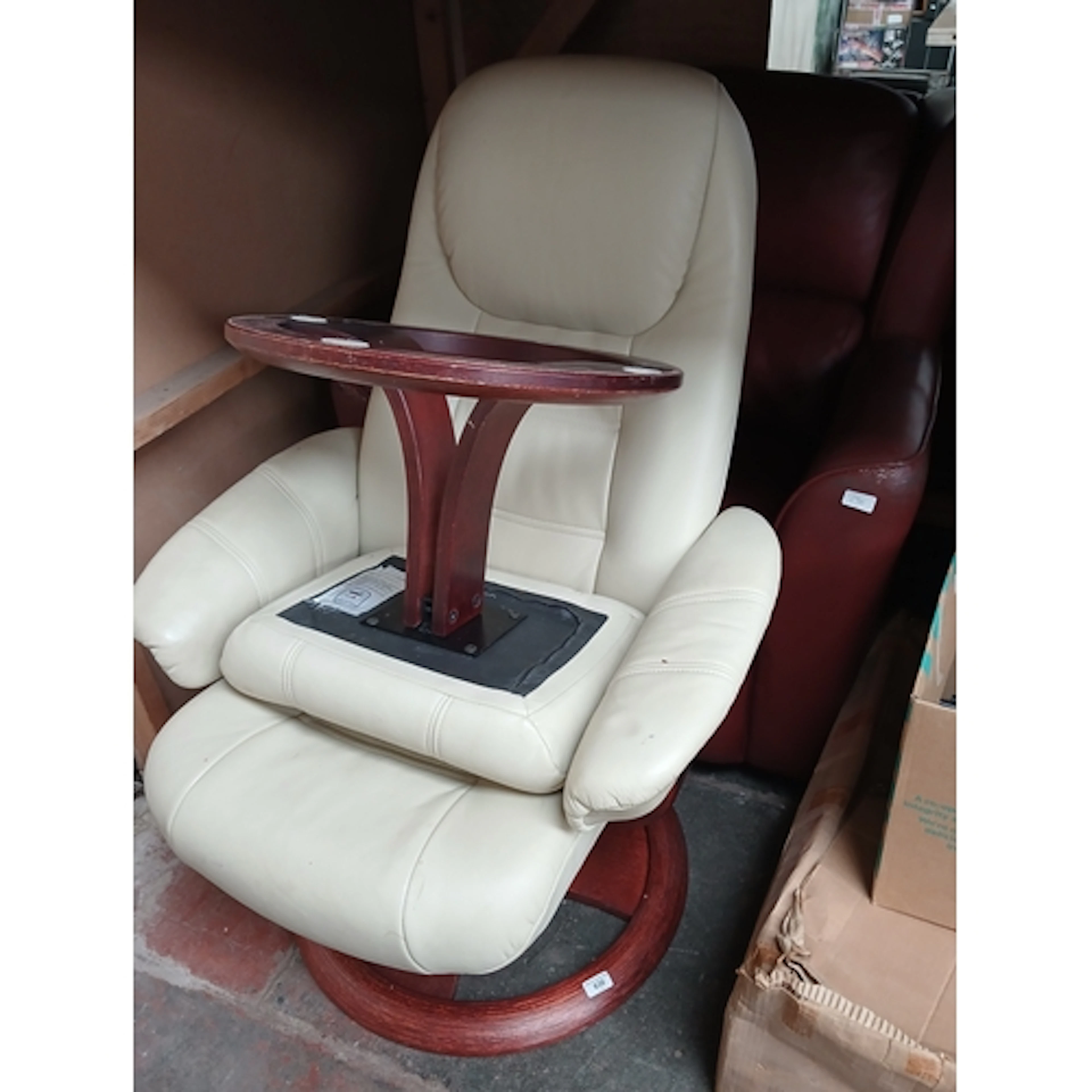 A red leather club type armchair and a cream leather swivel ...
