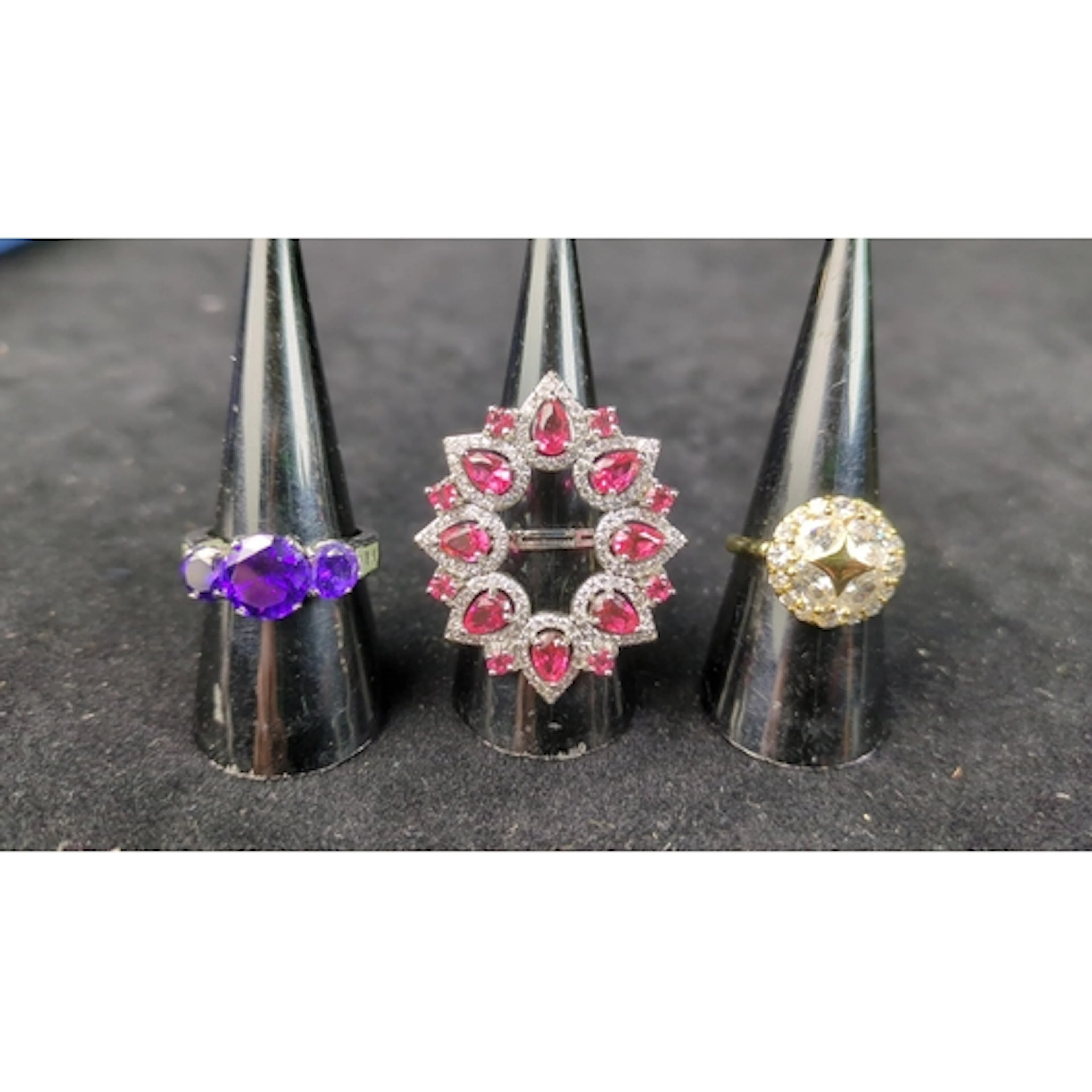 Three gem-set rings: one with purple faceted stones, one wit...