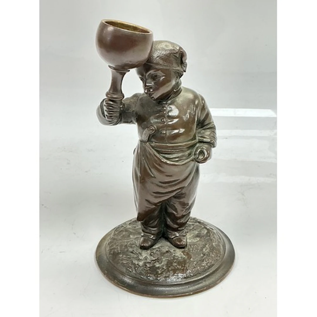 A small bronze figural candlestick of a late 19th Century tr...