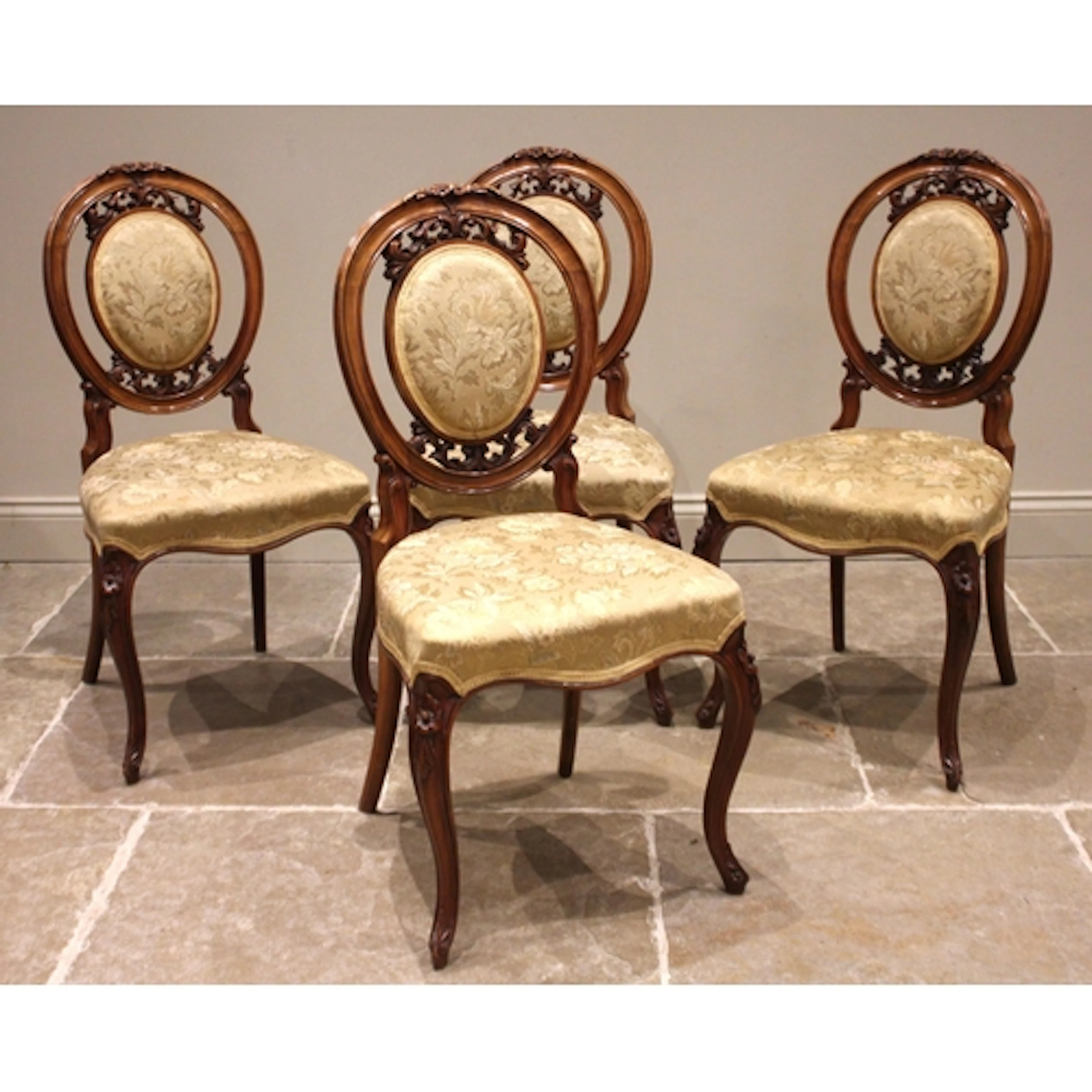 A set of four Victorian walnut cameo back salon chairs, each...
