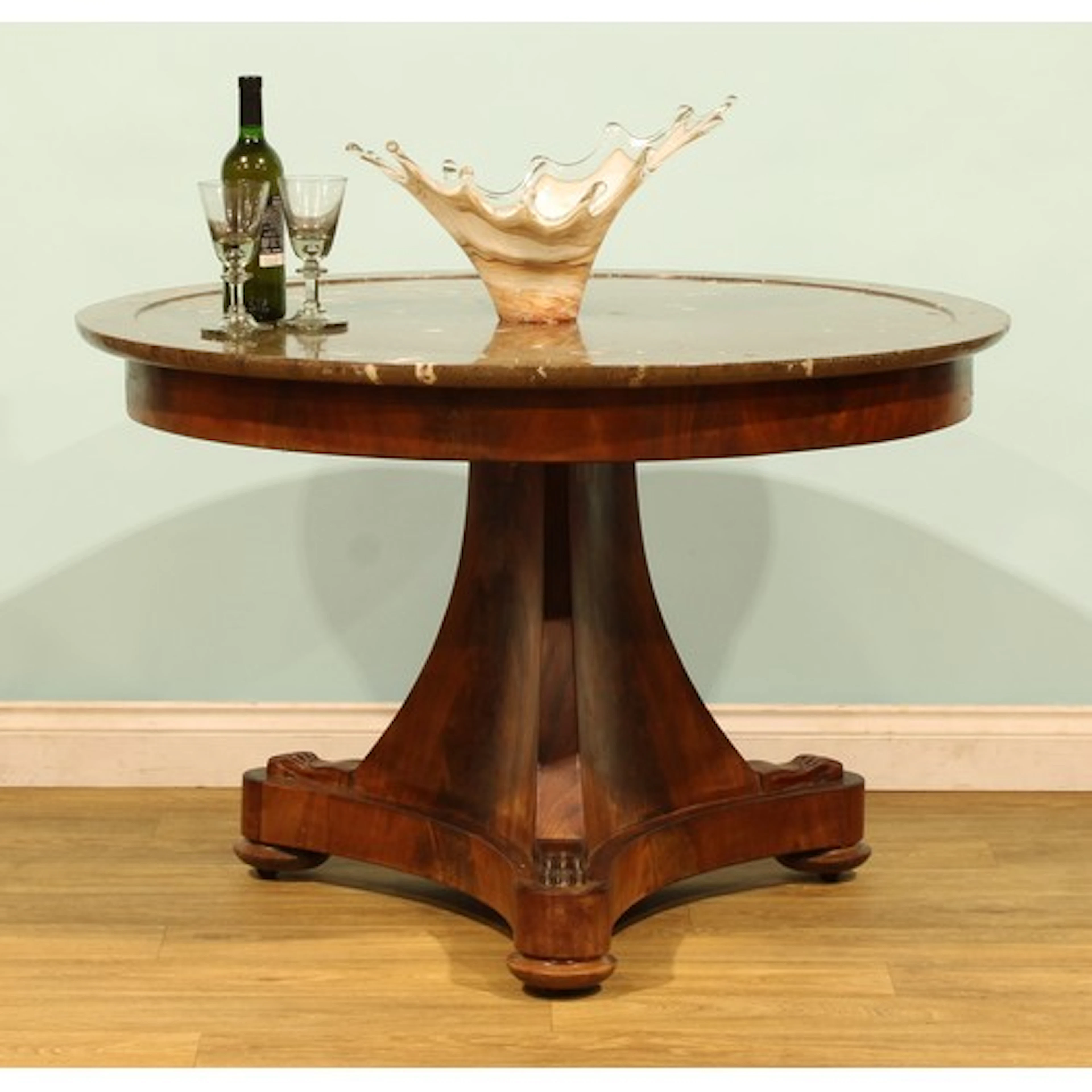 A 19th century French flame mahogany guéridon, in the Empire...