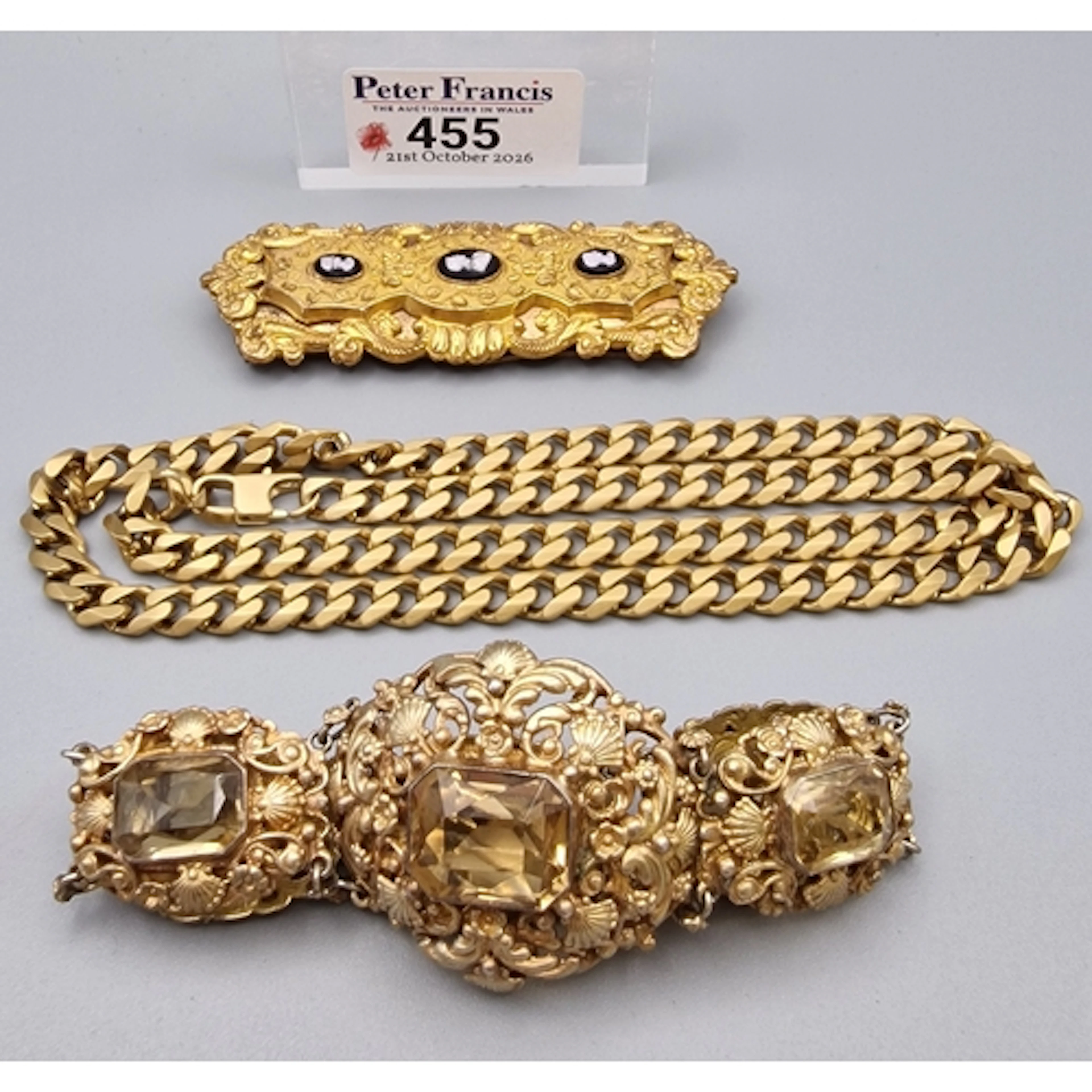 Gold toned curb-link chain, together with a gold tone cuff o...