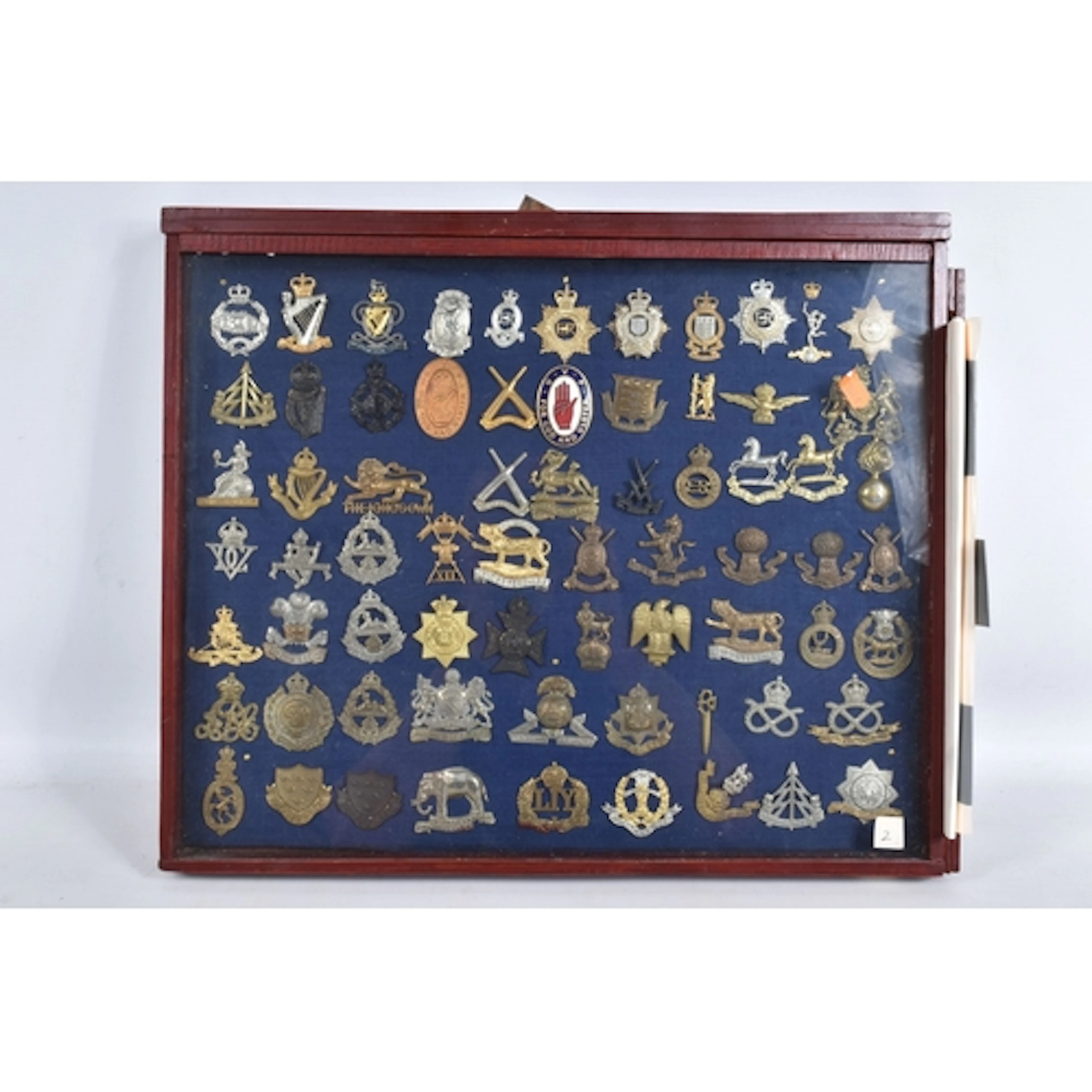 A GLAZED DISPLAY CASE CONTAINING AS ASSORTMENT OF MILITARY B...
