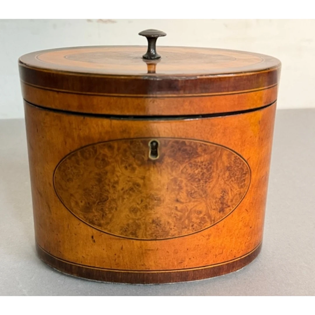 A late 18th century oval satinwood and burr walnut tea caddy...